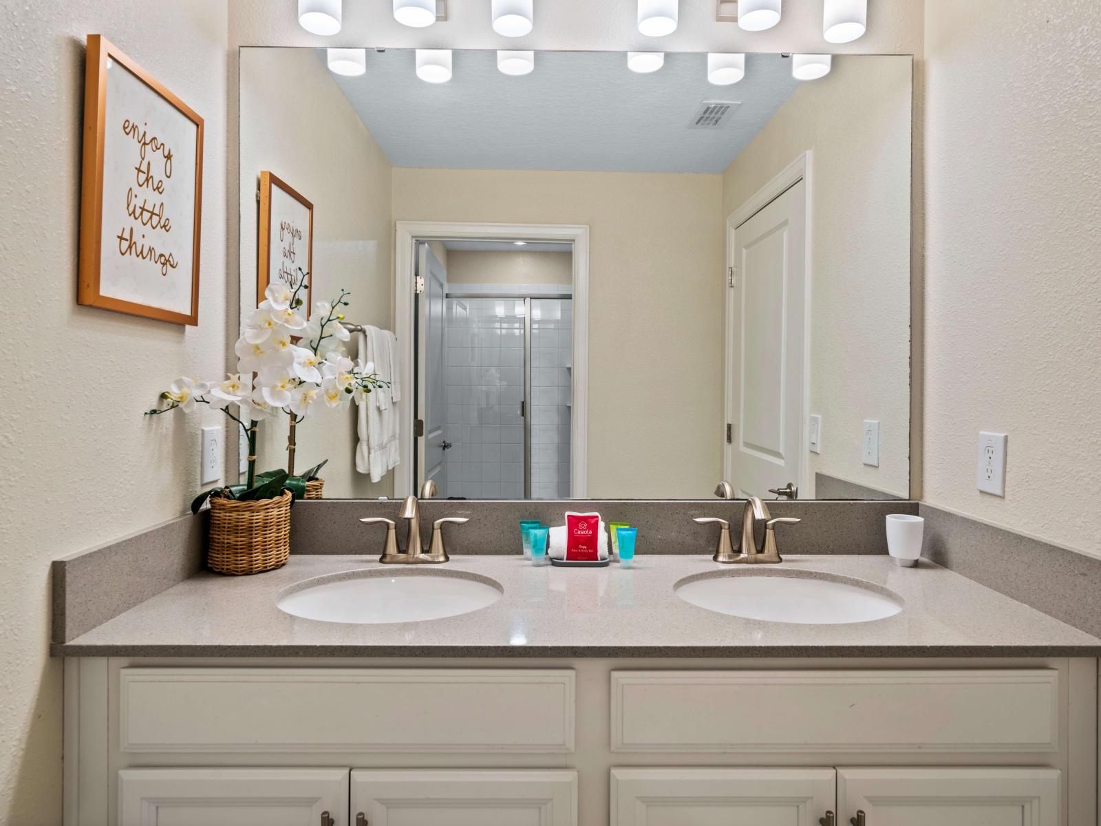 Swish bathroom of the townhouse in Kissimmee Florida - Lush double vanity with large mirror and upscale lighting - Sophisticated color palette creating a serene ambiance - Walk-in shower stall