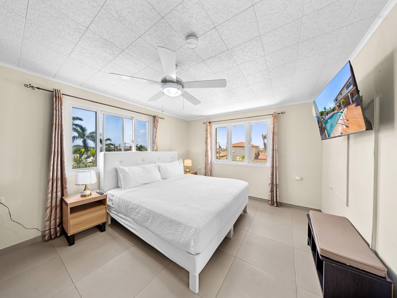 Drift off to sleep amidst refinement in elegant bedroom of the home in Noord Aruba - Your perfect haven offering king size comfy bed and beautiful outside views - Harmonious color palette creating a soothing atmosphere, smart TV for entertainment