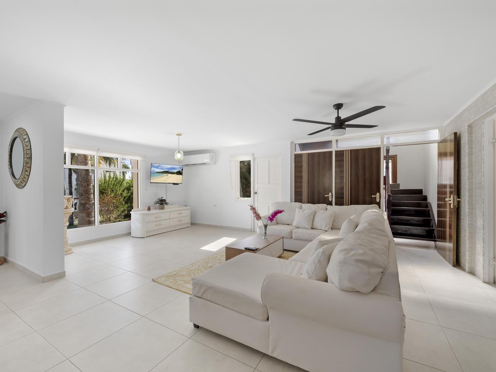 Savor the flavors of togetherness in open concept living and dining area of the home in Noord Aruba - Serene ambiance perfect for unwinding with comfy sofa and smart TV - Cozy retreat where you can relax and recharge in ultimate comfort