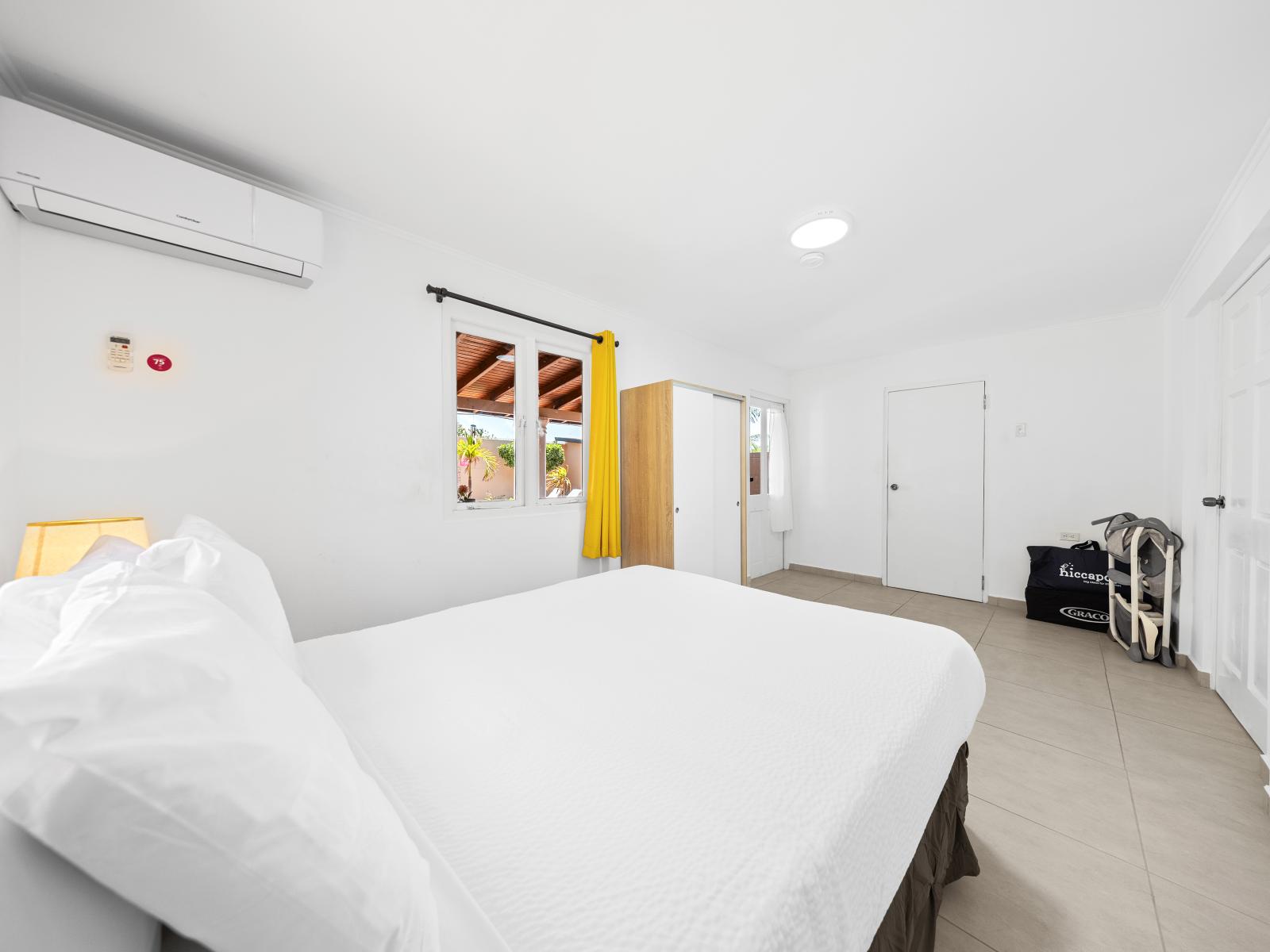 Experience the ultimate in relaxation in tranquil bedroom on the first floor of the home in Noord Aruba - Well-appointed bedroom with neutral tones for a calming atmosphere - Spacious bedroom featuring a plush double bed and plenty of storage