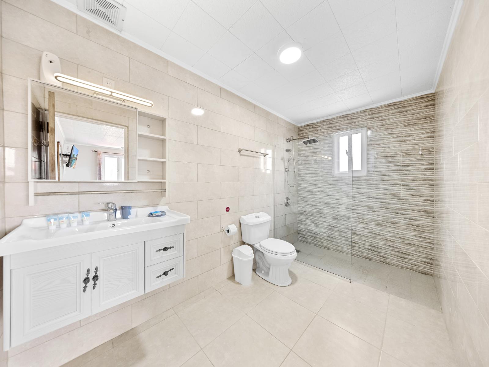 Experience convenience and comfort in well-maintained bathroom of the home in Noord Aruba - Inviting bathroom with a soothing color palette and chic vanity - Refresh and rejuvenate in inviting walk-in shower, the epitome of comfort