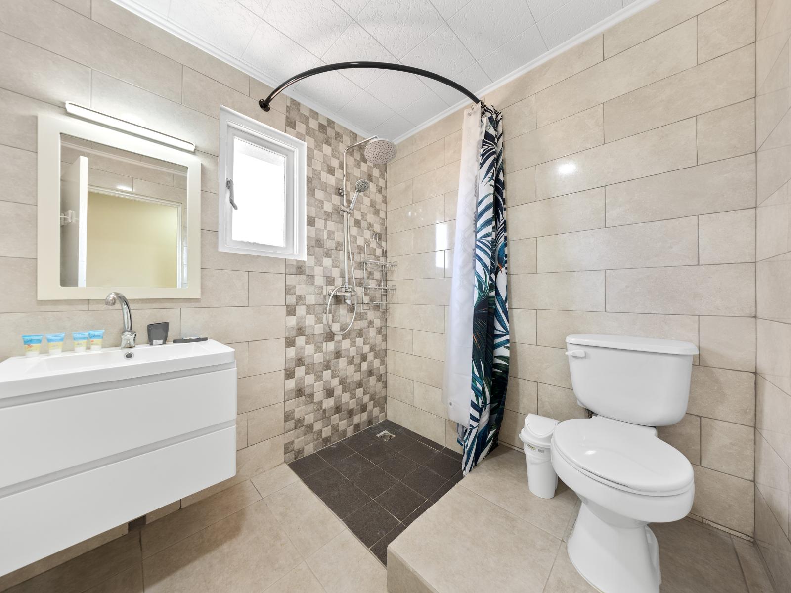 Escape the ordinary in lush bathroom of the home in Noord Aruba - Harmonious blend of classic and contemporary elements - Walk-in shower area with sliding curtain for sophistication