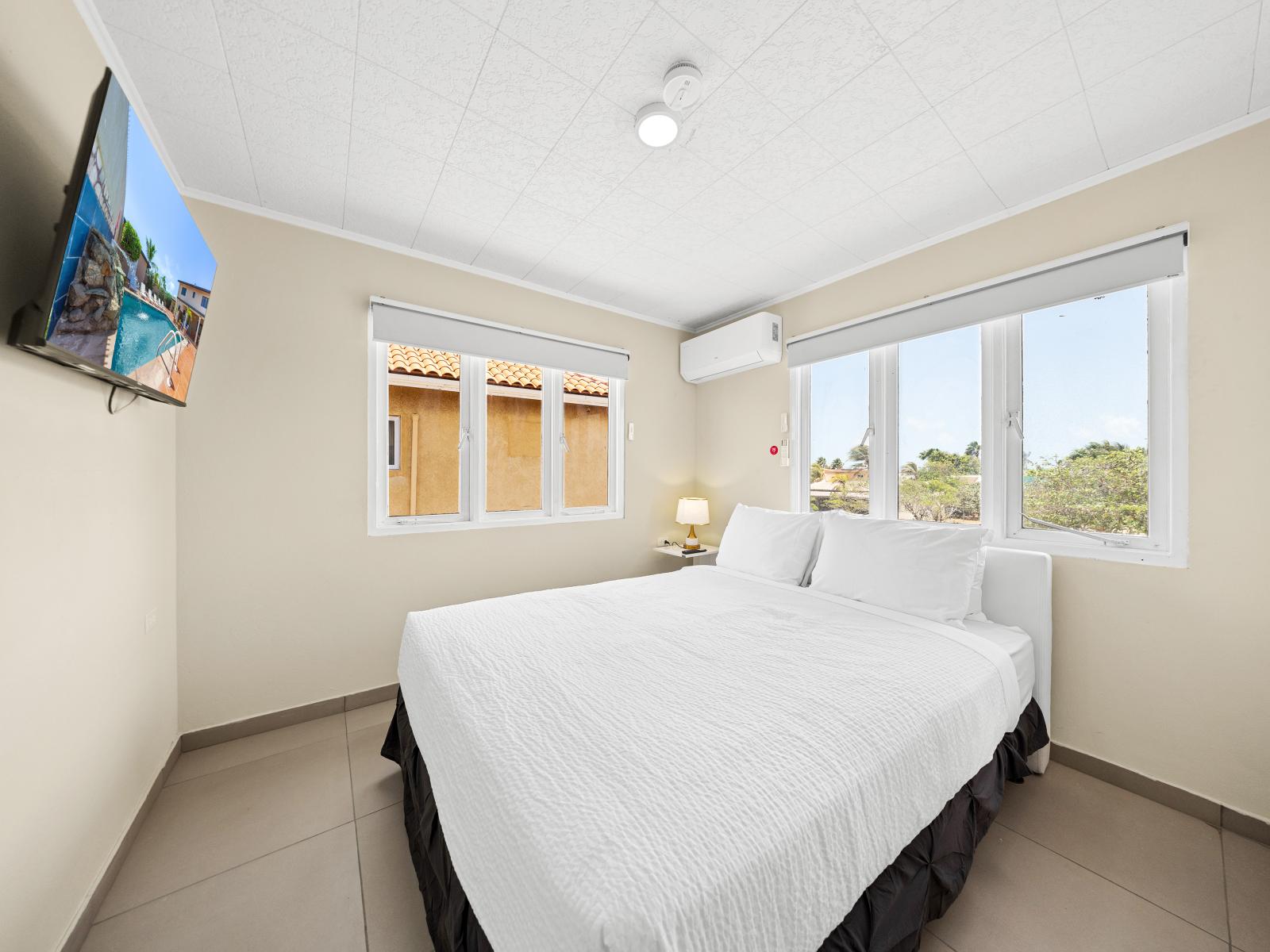 Discover the perfect blend of style in serene bedroom of the home in Noord Aruba - A relaxing space with queen size bed where you can recharge and rejuvenate - Minimalist decor, creating a clean and uncluttered sleeping space