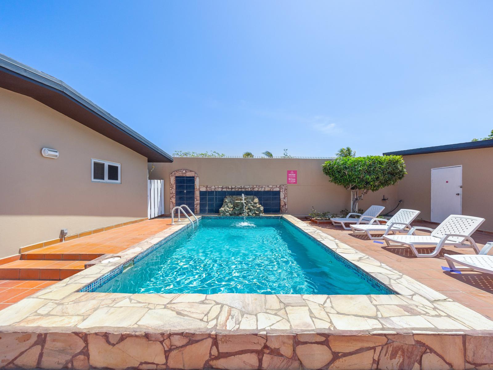 Refreshing outdoor shower by the pool of the home in Noord Aruba - Inviting poolside loungers for basking in the sunshine in peaceful environment - A peaceful ambiance where you can unwind and recharge your spirits