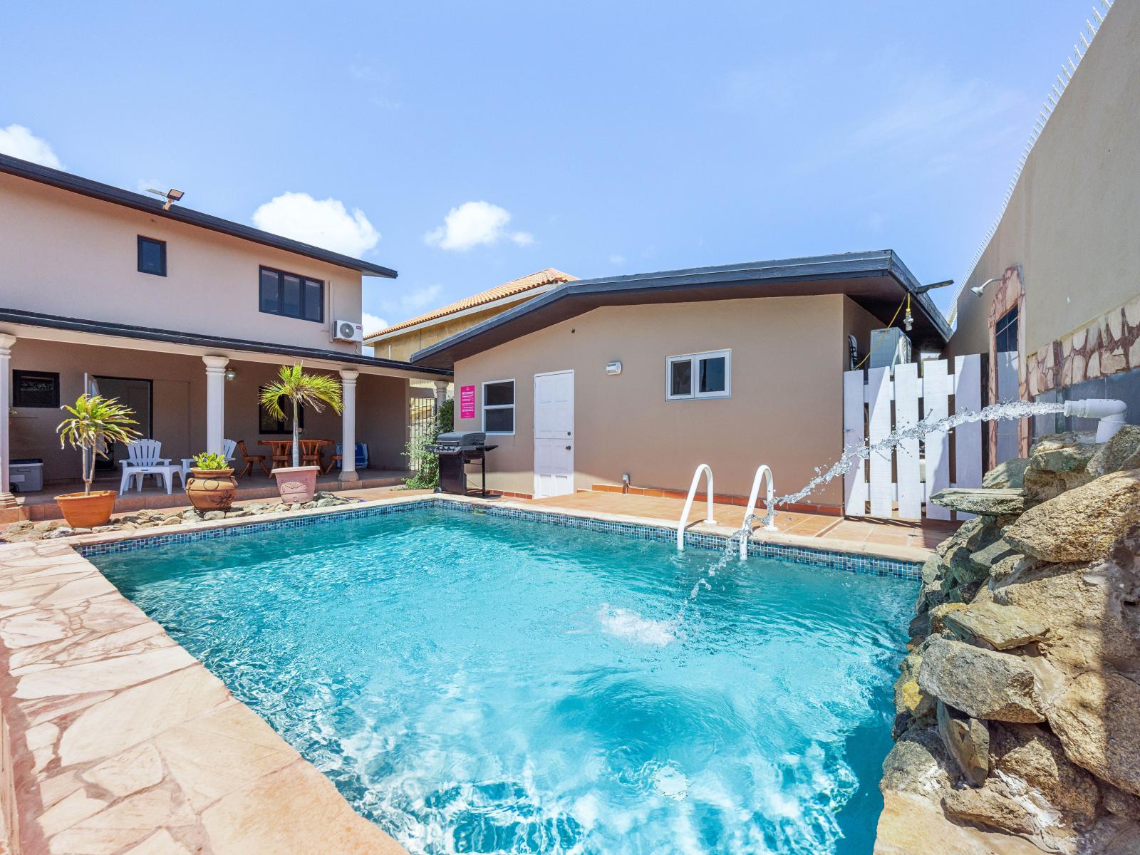 Refresh your senses with a dip in friendly pool of the home in Noord Aruba - Relaxing loungers for soaking up the sun's warm rays by the sparkling water - A peaceful atmosphere where you can unwind and recharge