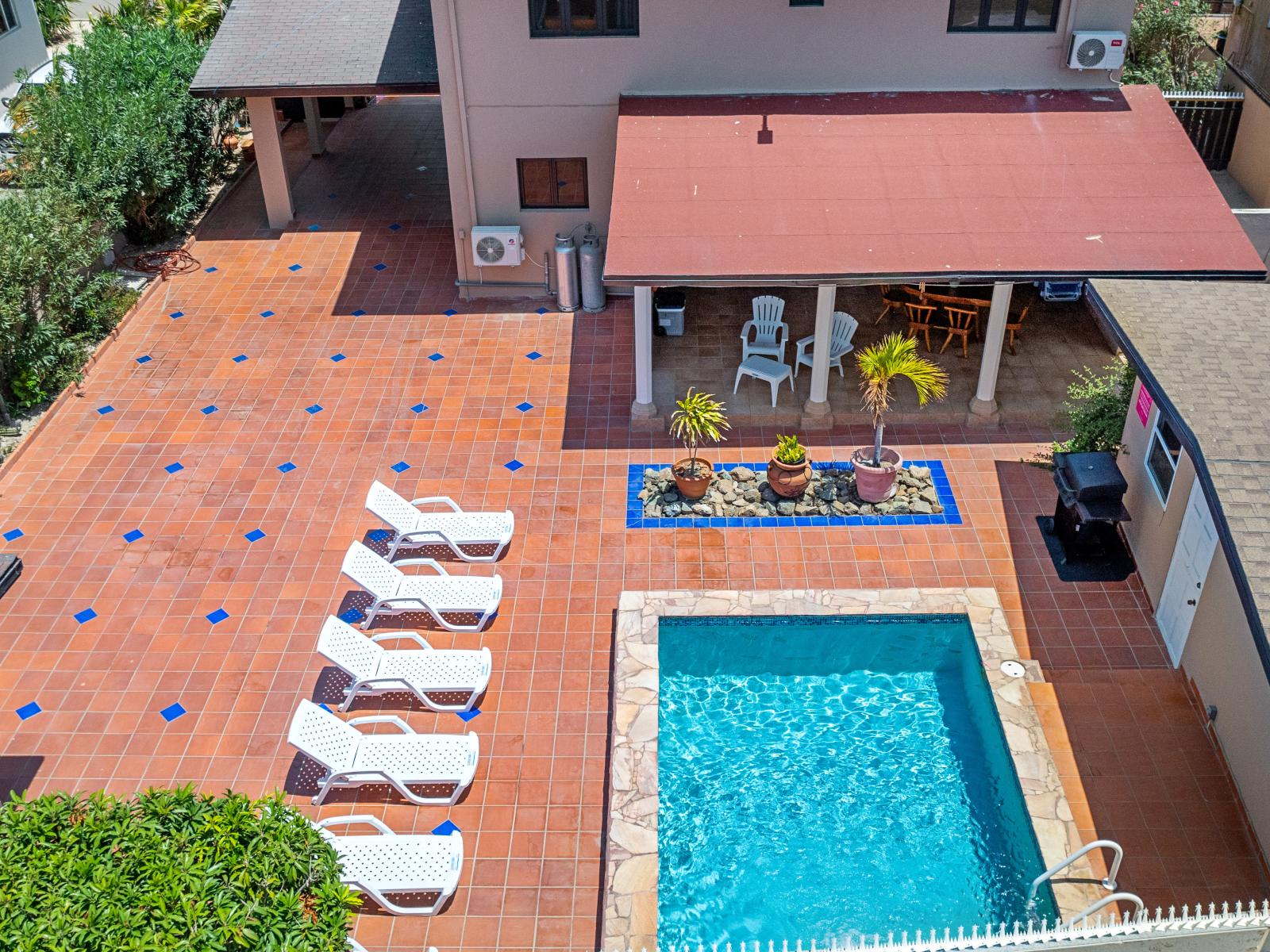 Lots of chairs by the pool for laying in the sun by the private pool of the home in Noord Aruba - Soak up the ambiance with a dip in stunning pool with sleek deck design - Plenty of shade options for sun-sensitive guests, leaving no one behind