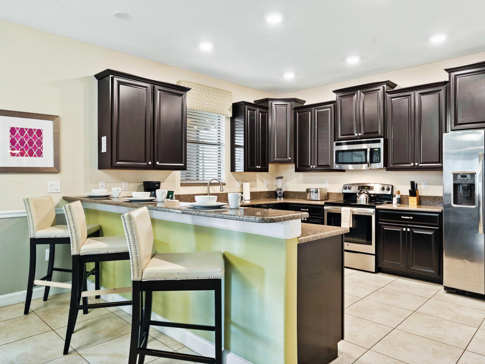 Open kitchen with stainless steel appliances and a chic, modern aesthetic with breakfast bar - Sleek granite countertops and plenty of storage make cooking a pleasure - Bright and inviting space, perfect for culinary creativity and socializing