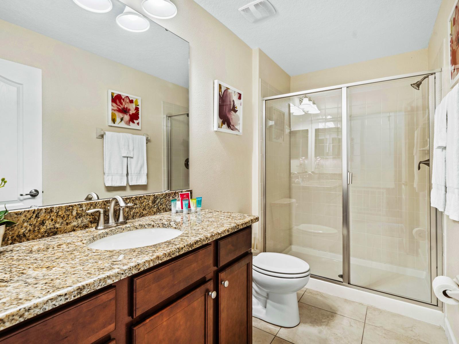 Recharge and renew in our elegant and meticulously maintained bathroom - Glass-enclosed shower area with soft upscale lighting and tasteful decor - Meticulously selected elements, from elegant tiles to faucets, grace the bathroom