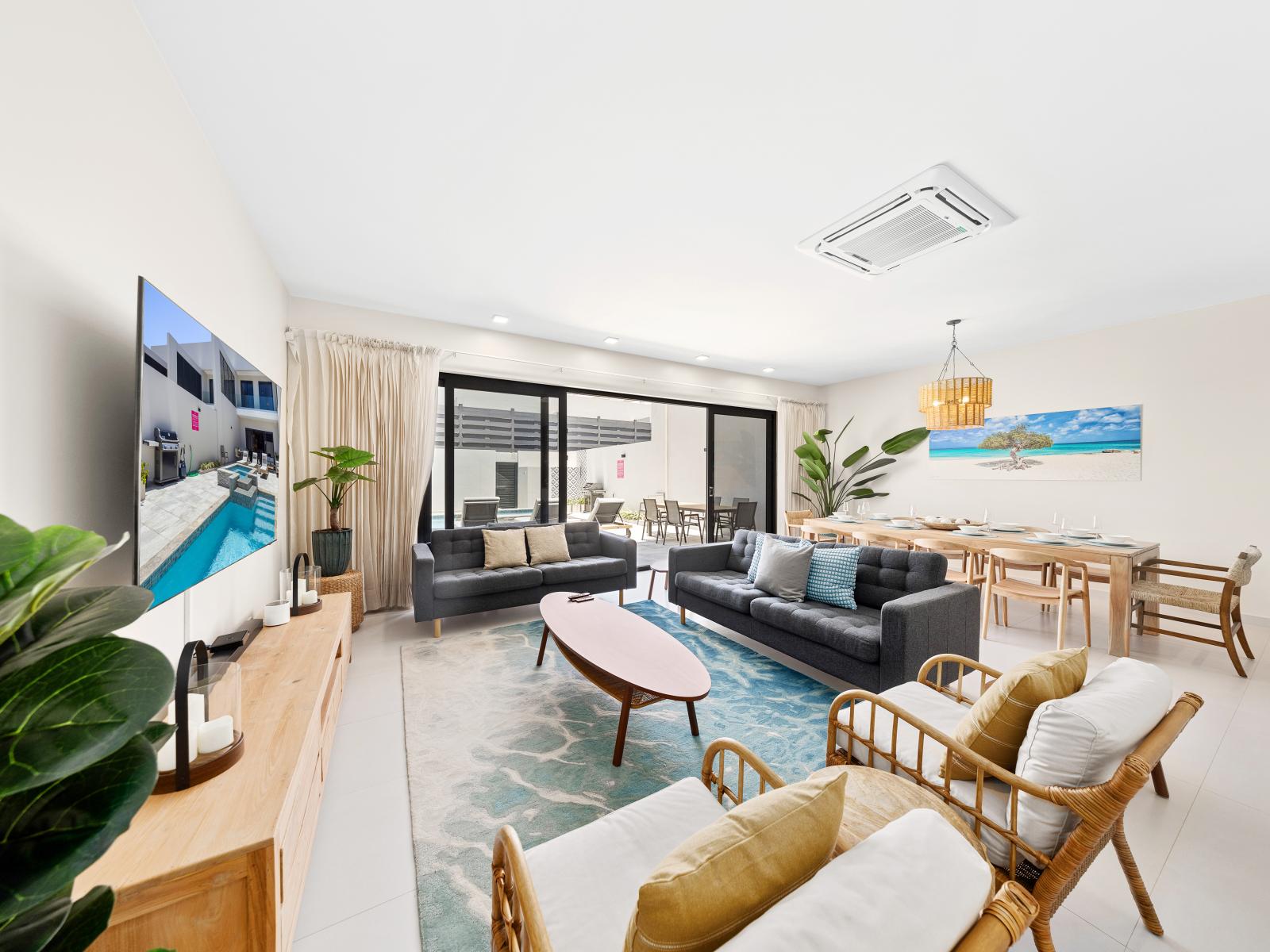 Beautifully decorated spacious living area of the apartment in Noord Aruba - Immerse yourself in living area equipped with smart TV for your favorite shows and movies and plush seating - Easy access to the backyard offering private pool