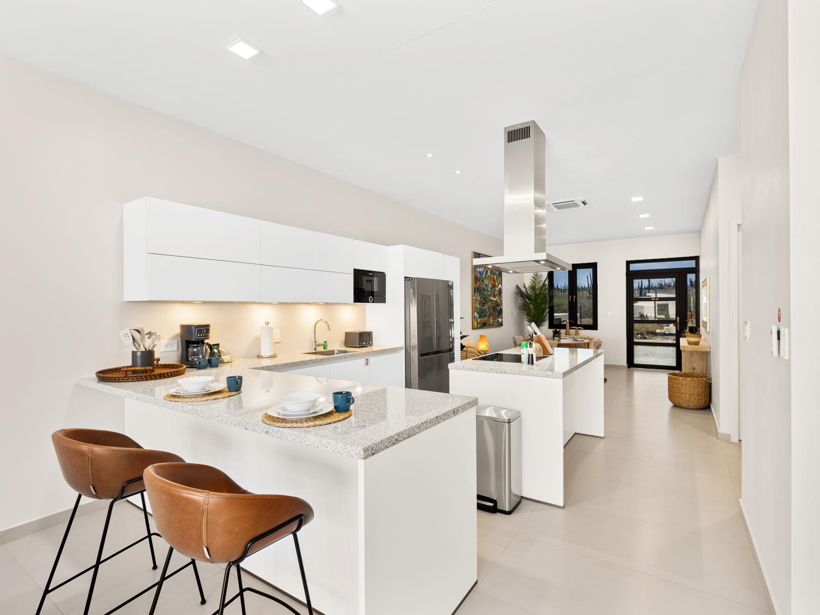 Embrace culinary adventures in modern fully equipped kitchen of the apartment in Noord Aruba - Clean lines and minimalist aesthetics define the contemporary design - Ergonomic features enhance the ease of use like breakfast bar and high chairs