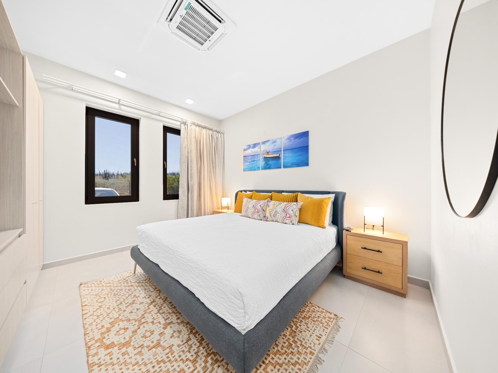 Escape to comfort and elegance in inviting bedroom of the apartment in Noord Aruba - King size bed with plush bedding and tranquil decor promise a restful night's sleep - Thoughtfully designed bedroom featuring functional and modern furniture