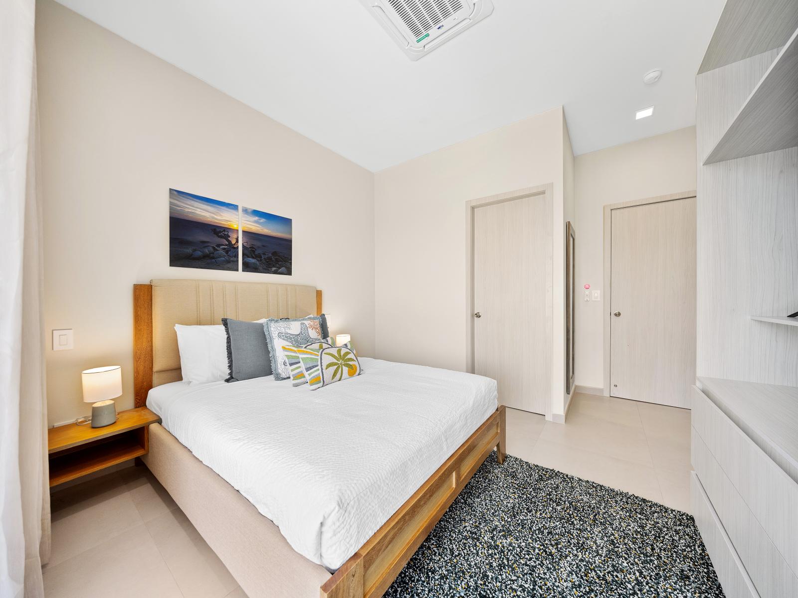 Experience the height of comfort in plush bedroom on  second floor of the apartment in Noord Aruba - Luxurious linens and tasteful decor invite you to unwind in the queen size bed - Serene space with tranquil color palette and flat screen smart TV