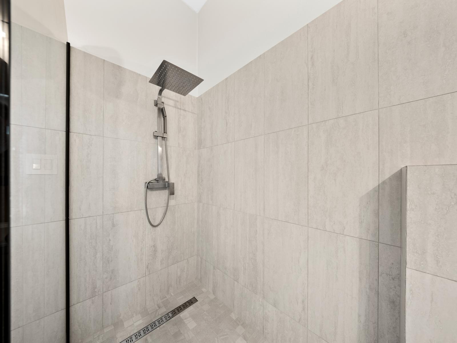 Refresh and rejuvenate in sleek bathroom oasis of the apartment in Noord Aruba - Sleek walk-in shower, complete with adjustable water settings and convenient amenities - Minimalist design and quality finishes create a serene retreat