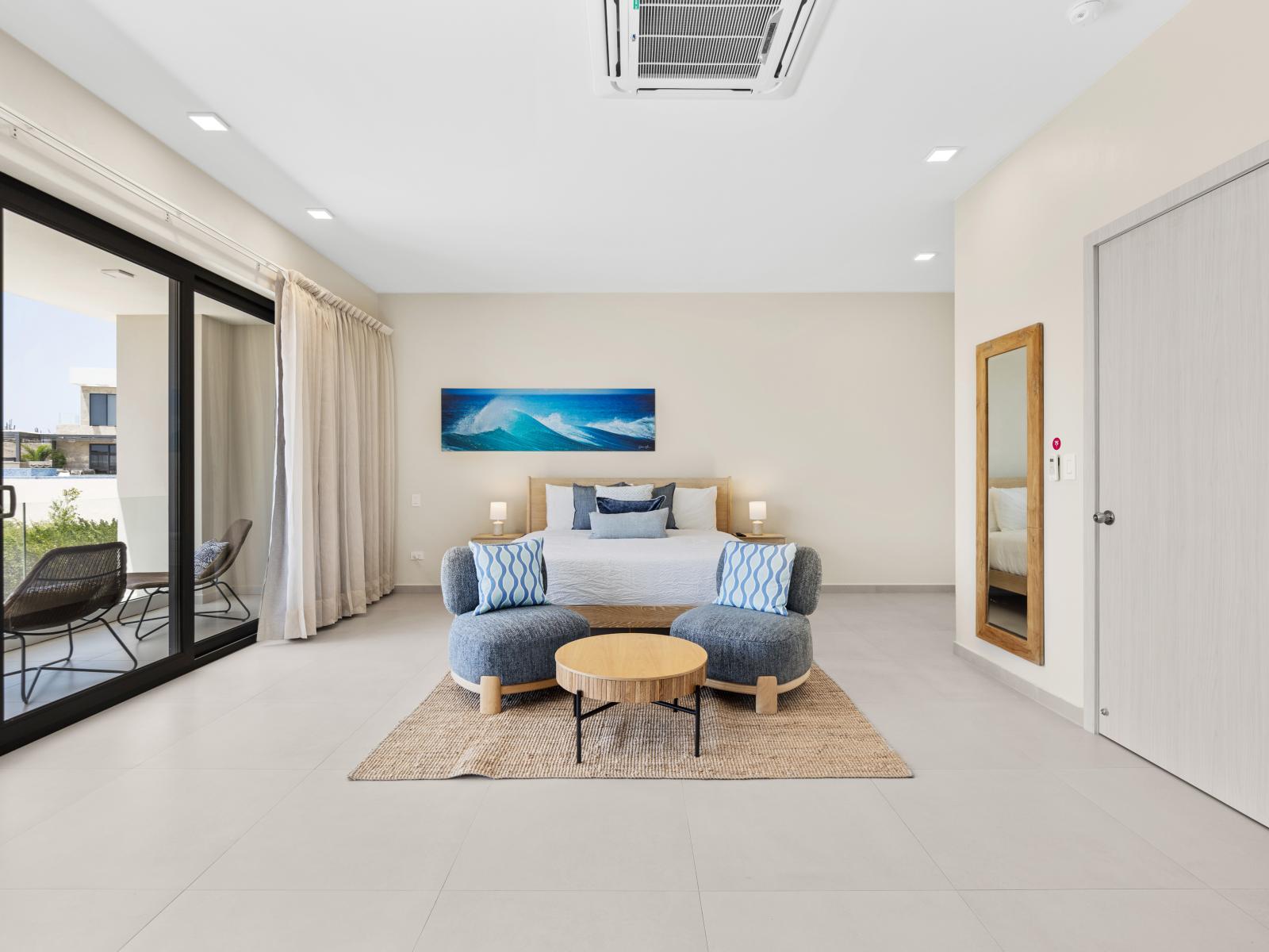 Experience tranquility in spacious bedroom sanctuary of the apartment in Noord Aruba - Offers a plush king size bed, private balcony with seating and a full length mirror - Rustic accents and modern comforts come together for a memorable stay