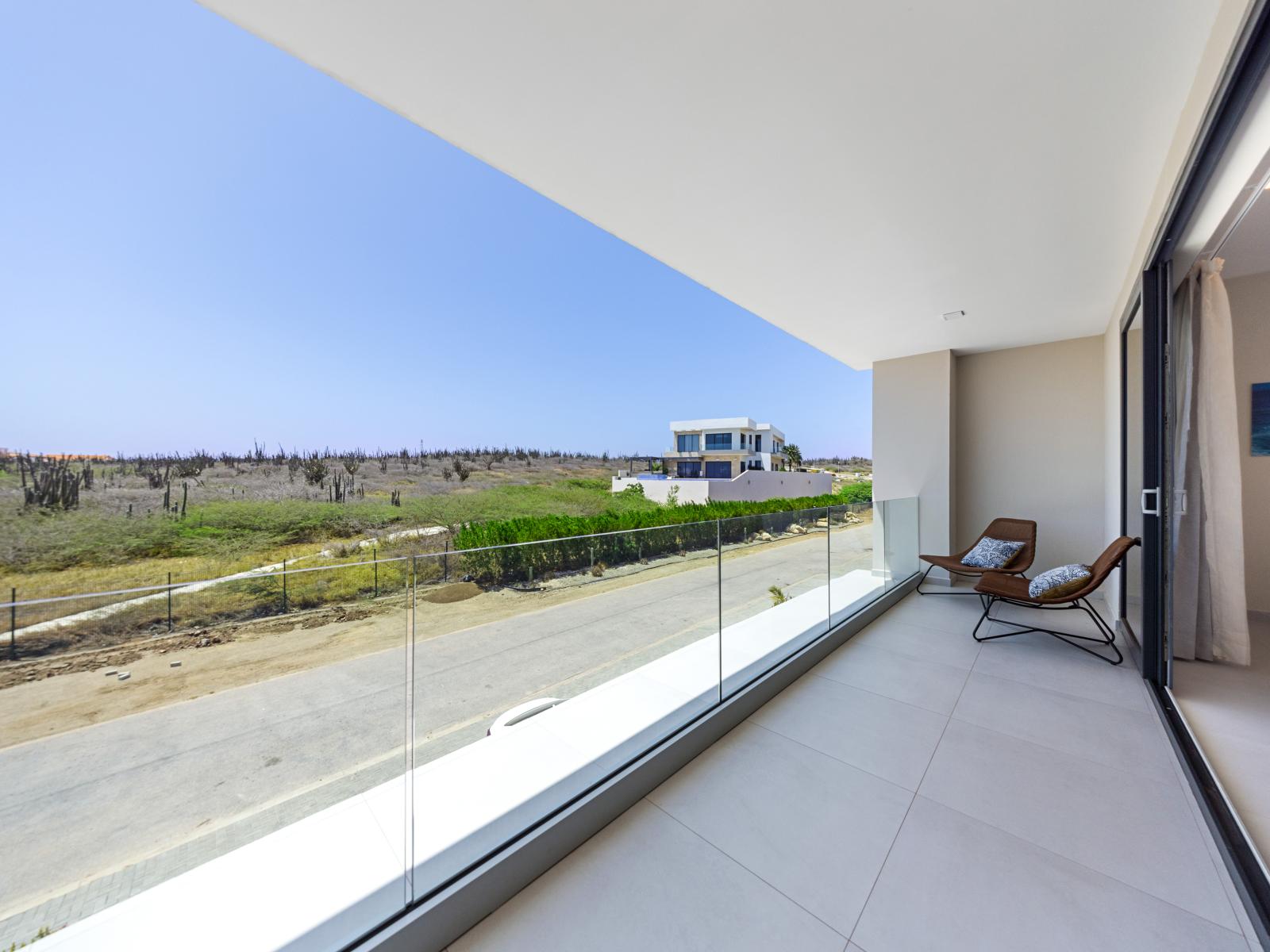 Cozy seating options with beautiful view from the balcony of the apartment in Noord Aruba - Stylish bedroom retreat, where plush bedding and thoughtful touches ensure a comfortable stay - Enjoy the perfect blend of comfort and ambiance