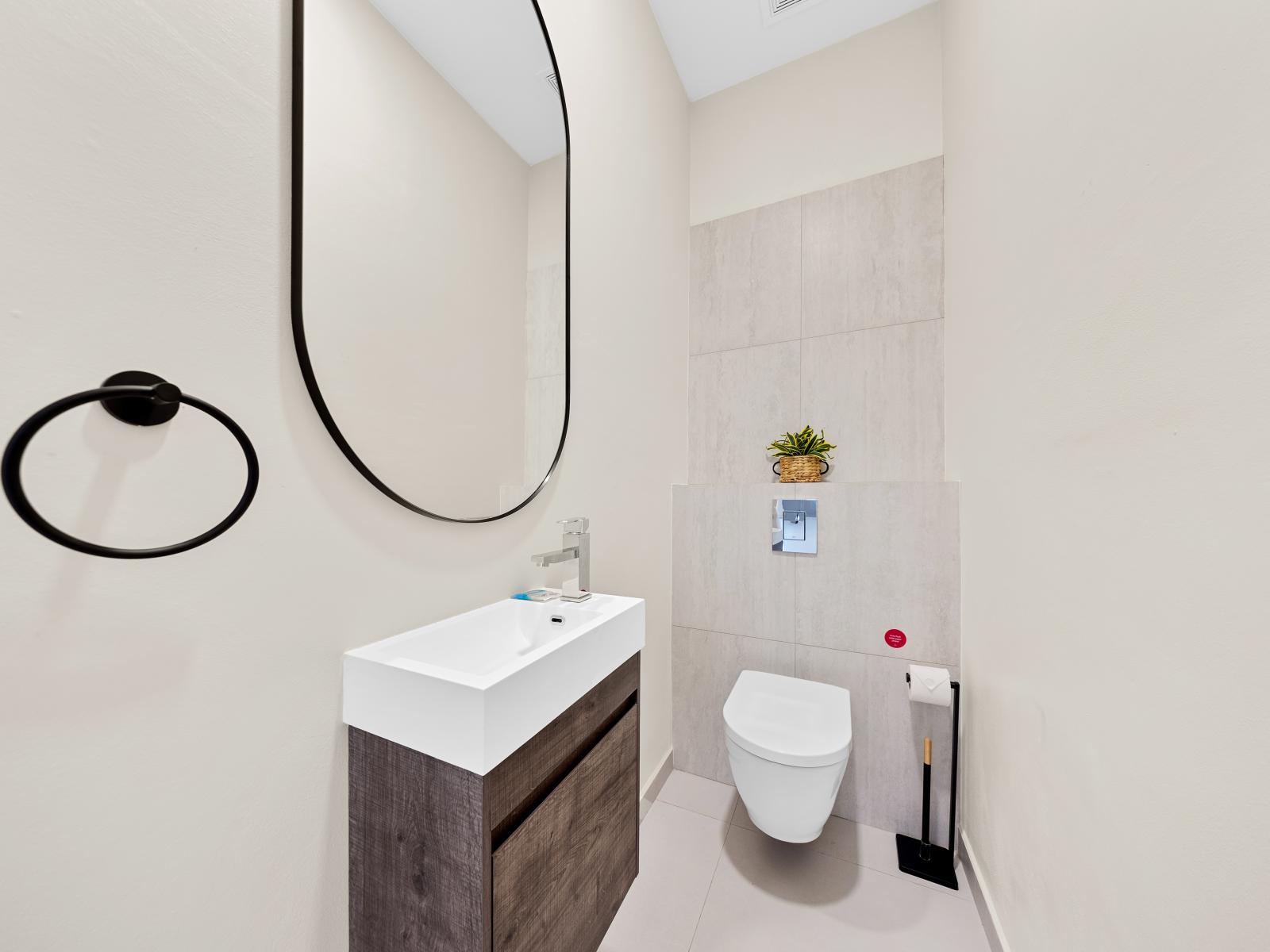 Freshen up in style in chic half bathroom of the apartment in Noord Aruba - Featuring modern fixtures and elegant fixtures for a quick refresh - Experience convenience and comfort, perfect for a quick pit stop before heading out to explore