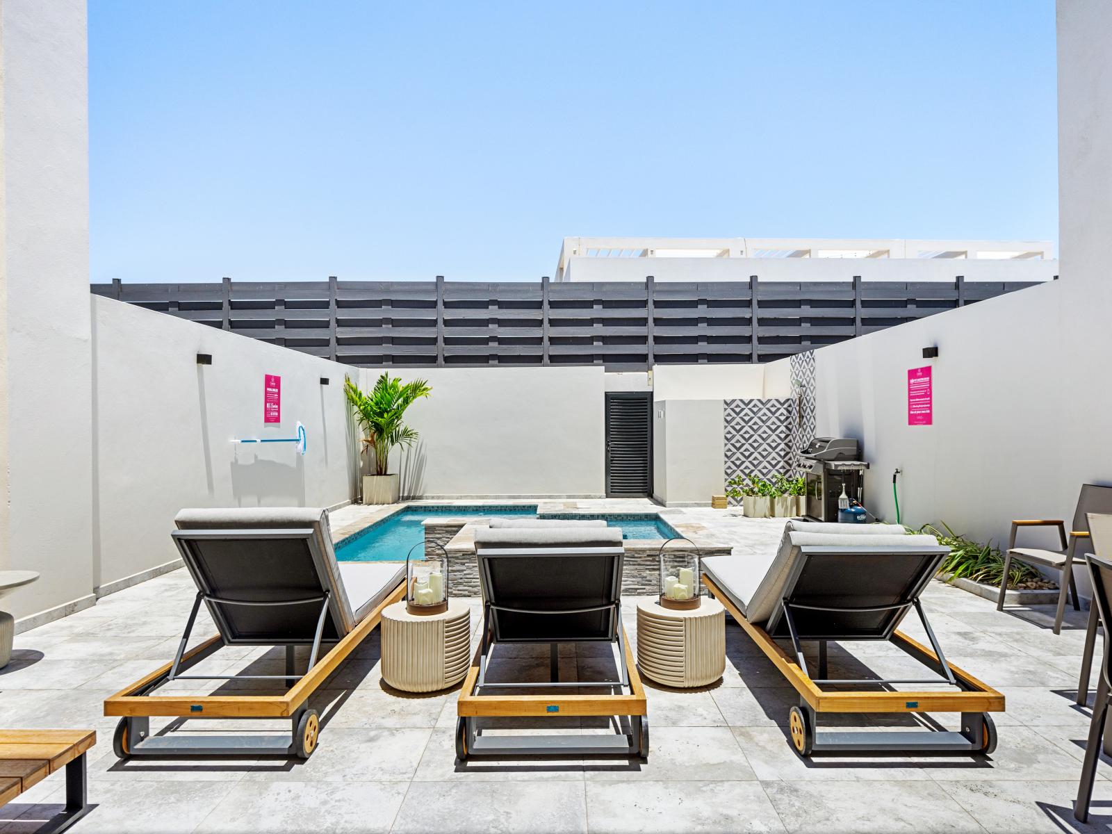 Lots of chairs by the pool for laying in the sun by the private pool of the apartment in Noord Aruba - Bask in the sunshine and air as you relax on the comfortable lounge chairs - Experience outdoor relaxation at its in cozy and inviting space