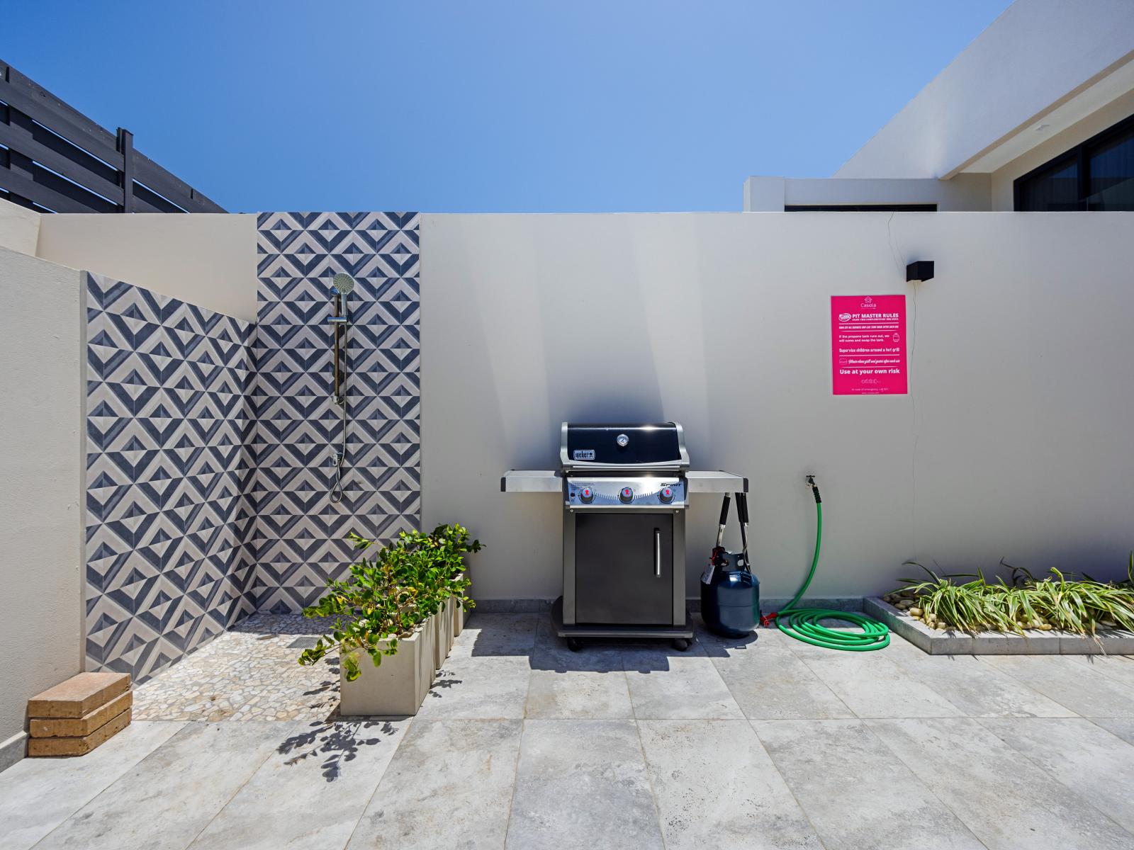 Experience outdoor cooking in well-equipped BBQ area by the outdoor shower of the apartment in Noord Aruba - Grill up your favorite meals and dine al fresco amidst beautiful surroundings - Perfect spot for enjoying meals and soaking up the sunshine