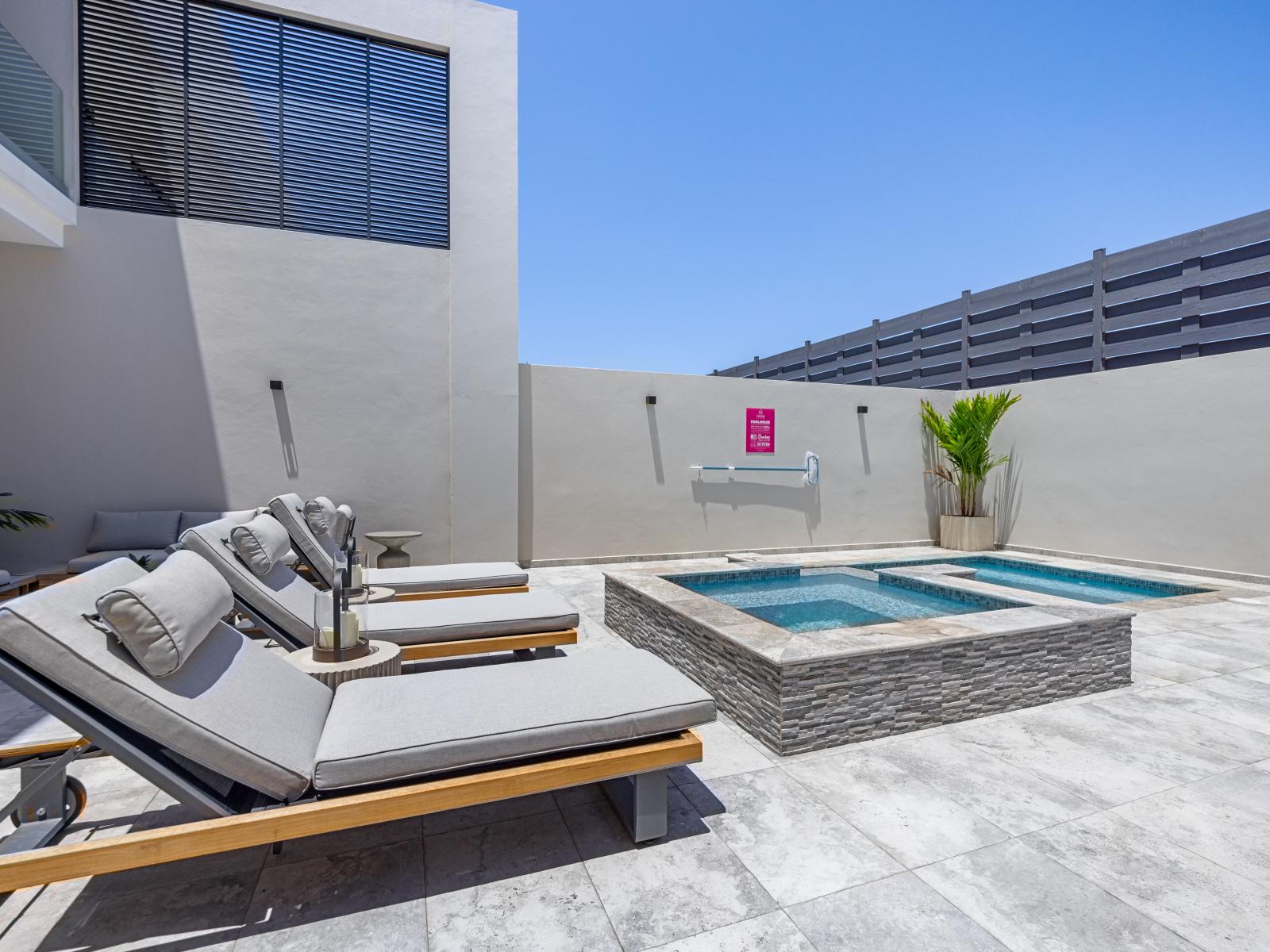 Refreshing pool with plenty of lounge chairs to soak up the sun in the backyard of the apartment in Noord Aruba - Where laughter and memories are made against the backdrop of sparkling waters - Every moment is met with relaxation and rejuvenation