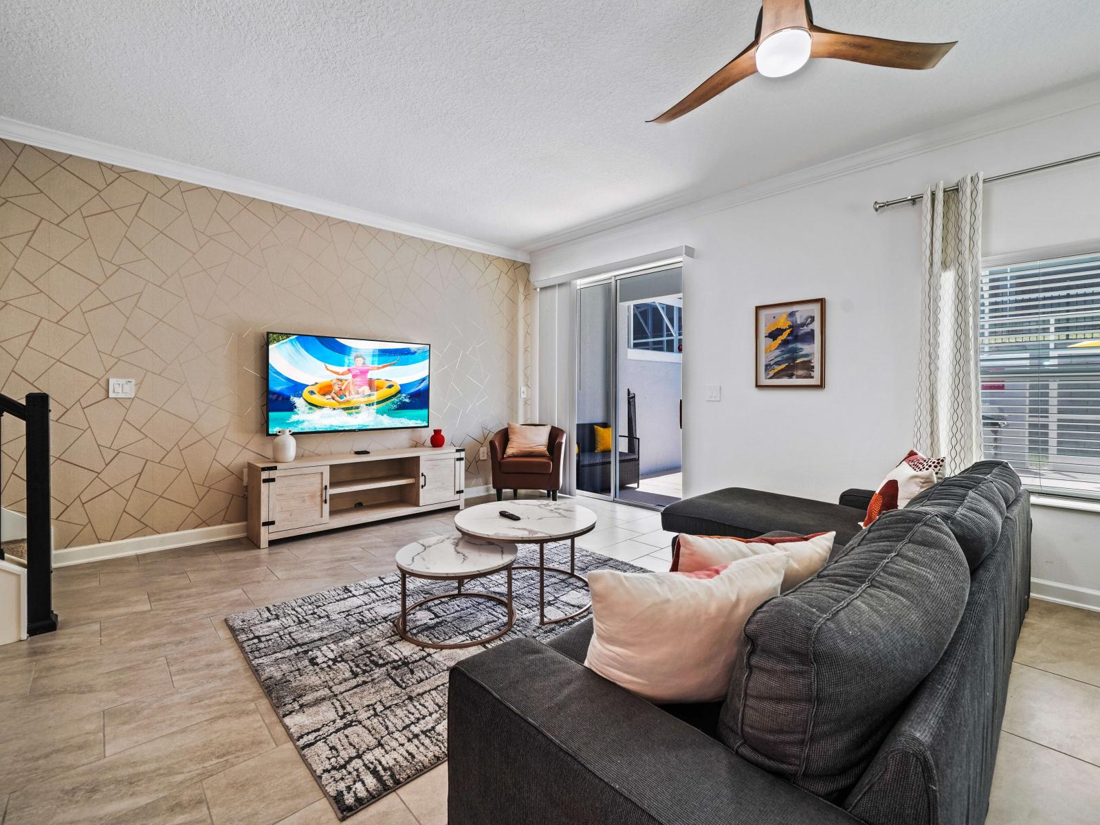 A harmonious blend of comfort and style awaits in spacious living area of the townhouse in Davenport Florida - Unwind in style in inviting space designed for relaxation with plush sofa - Smart TV and easy access to pool for endless entertainment