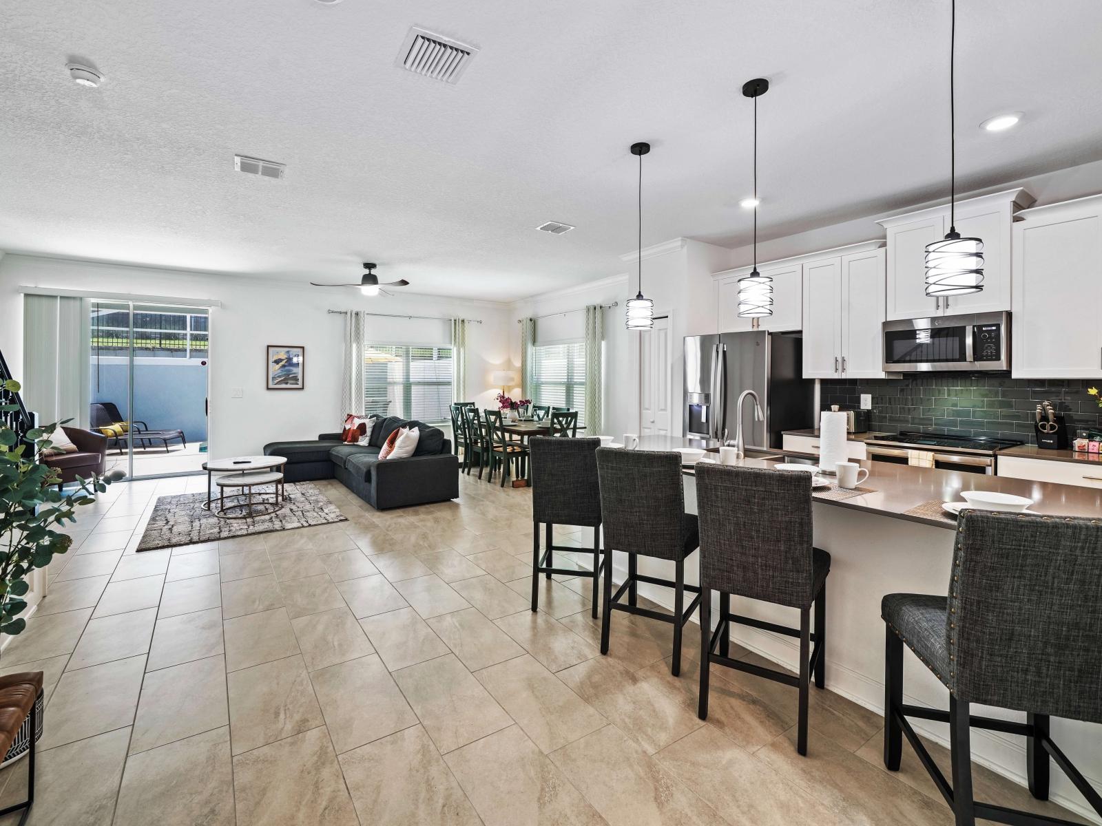 Whip up culinary delights in a sleek and modern kitchen of the townhouse in Davenport Florida - Contemporary design with clean lines and minimalist aesthetics with high chairs - Functional layout designed for efficient meal preparation