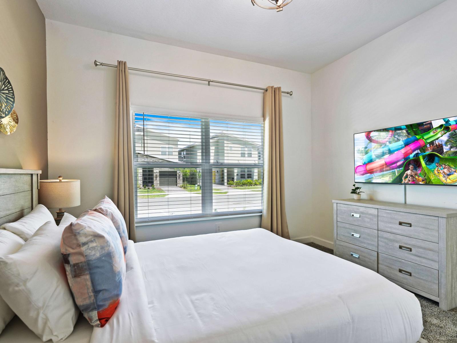 Escape to comfort in stylishly appointed bedroom of the townhouse in Davenport Florida - Offering queen size bed for restful nights and a smart TV - Discover your personal sanctuary in meticulously designed space with beautiful outside views