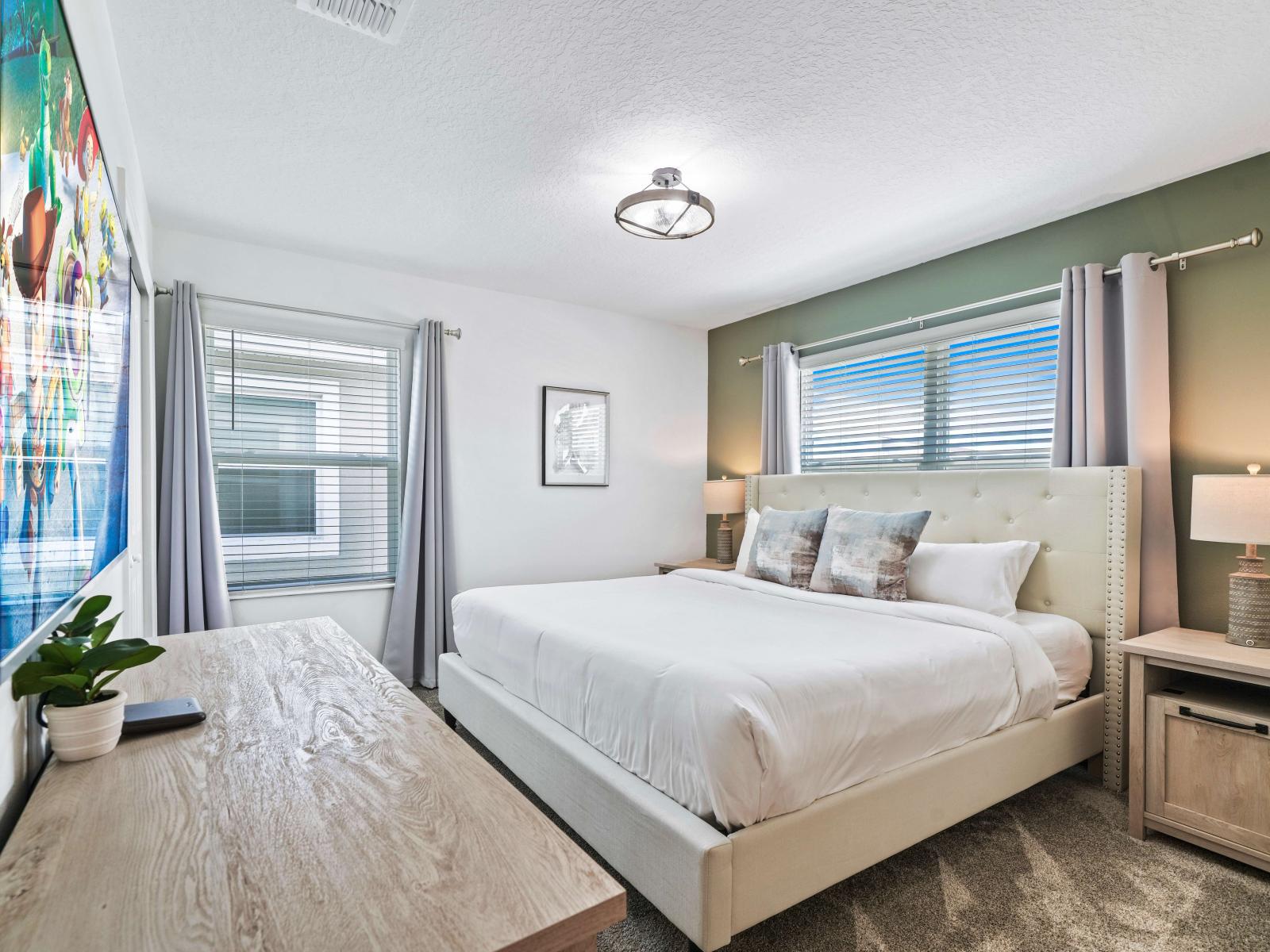 Relax, unwind, and dream away in our tranquil  bedroom of the townhouse in Davenport Florida - Features a king size bed, smart TV and attached bathroom for privacy - Bright bedroom with large windows for natural illumination