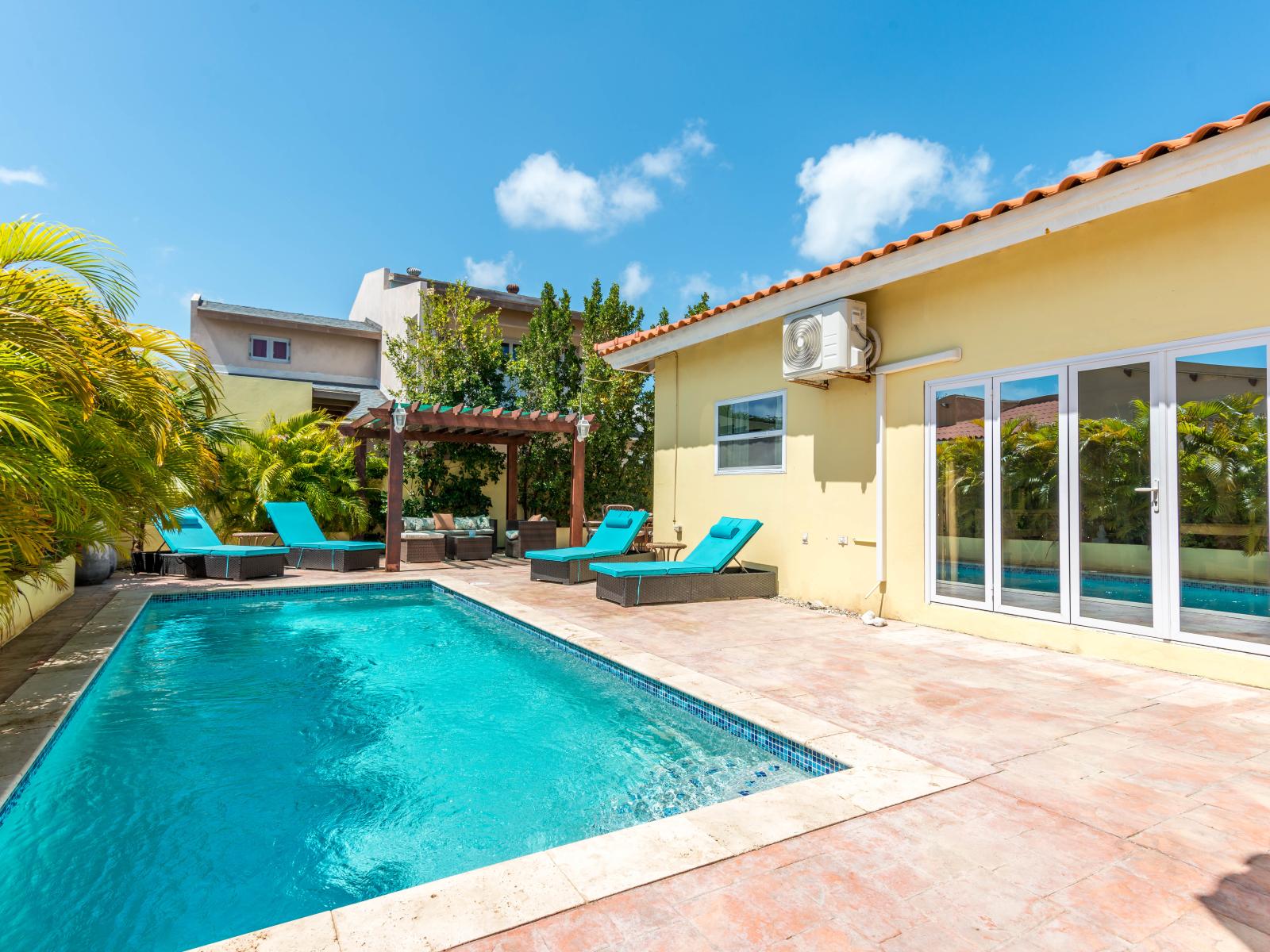Experience poolside perfection at private pool of the home in Noord Aruba - Shimmering waters and lush landscaping creating a tranquil oasis - Comfortable seating areas for soak in the warm rays of the Aruba sun
