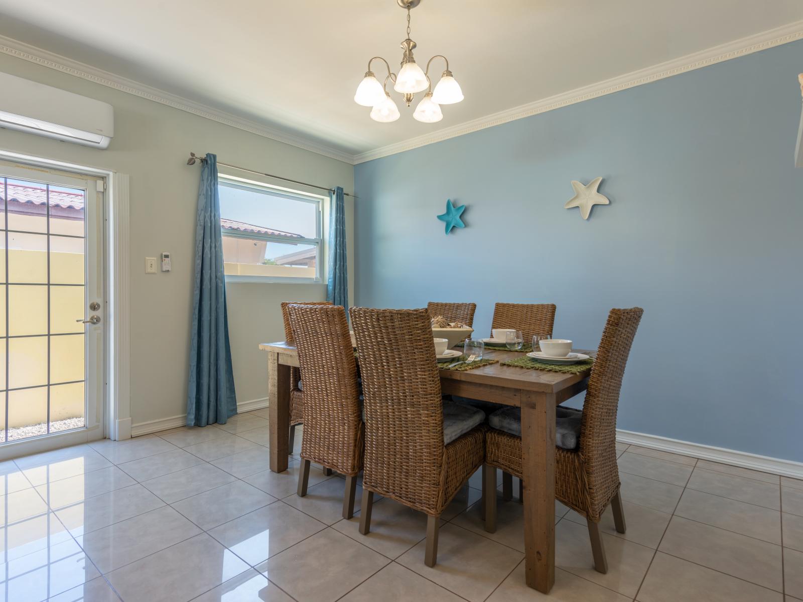 A symphony of taste and elegance awaits at dining area of the home in Noord Aruba - Indulge in culinary delights amidst refined ambiance at this dining table for 6 people - Celebrate togetherness and delicious cuisine in charming space