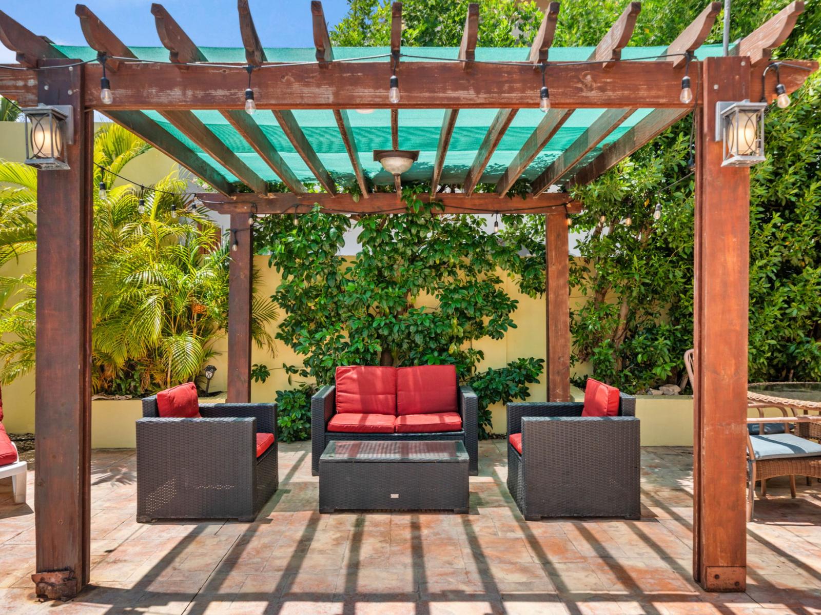 Enjoy the tranquility of the outdoors from the comfort of outdoor seating area of the home in Noord Aruba - Lots of chairs by the pool for laying in the sun with pool views - Bask in sun-kissed luxury near the water and unwind