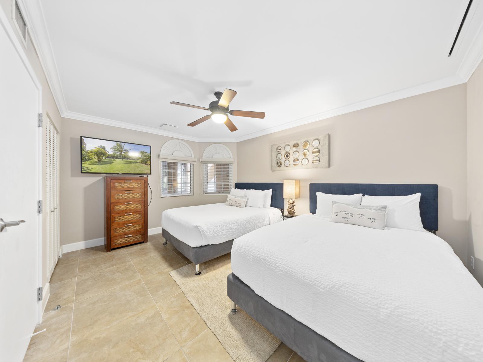 Experience relaxation in the first bedroom, boasting two queen beds and an elegant ensuite bathroom.