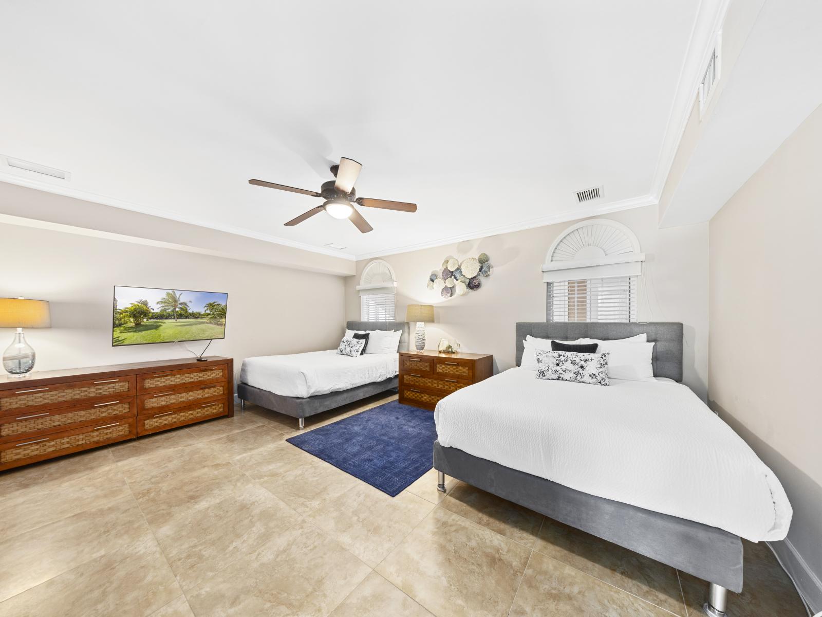 Enjoy the comfort of our second bedroom, equipped with two queen beds, a smart TV, and a modern ensuite bathroom.