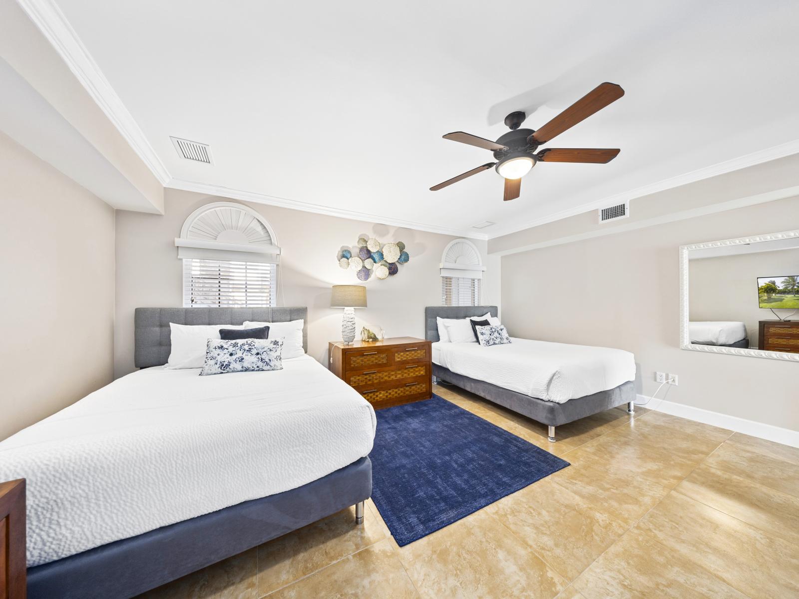 Spacious and inviting, our second bedroom features two queen beds, a smart TV, and an ensuite bathroom for ultimate comfort.