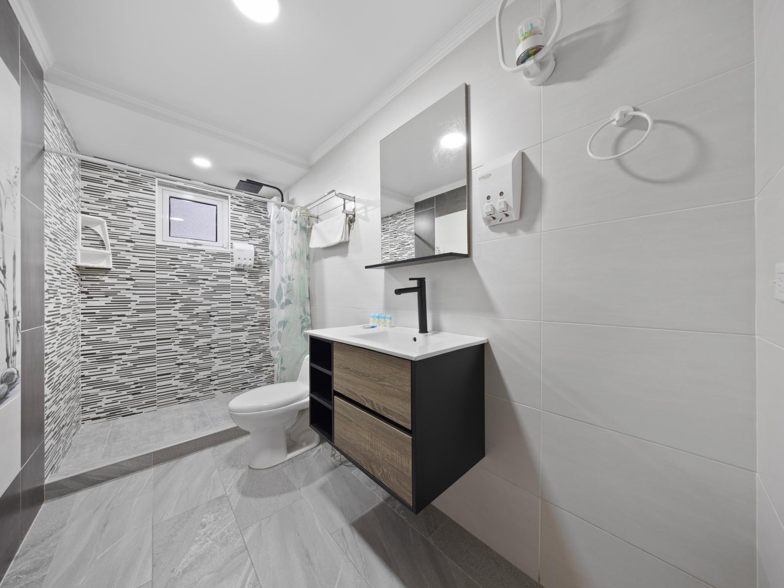 Cherish moments of solitude in the bathroom of the home in Aruba - Spacious walk-in shower area, where peace and relaxation abound after a long day of adventure - Relax in an inviting setting featuring soothing colors for tranquility