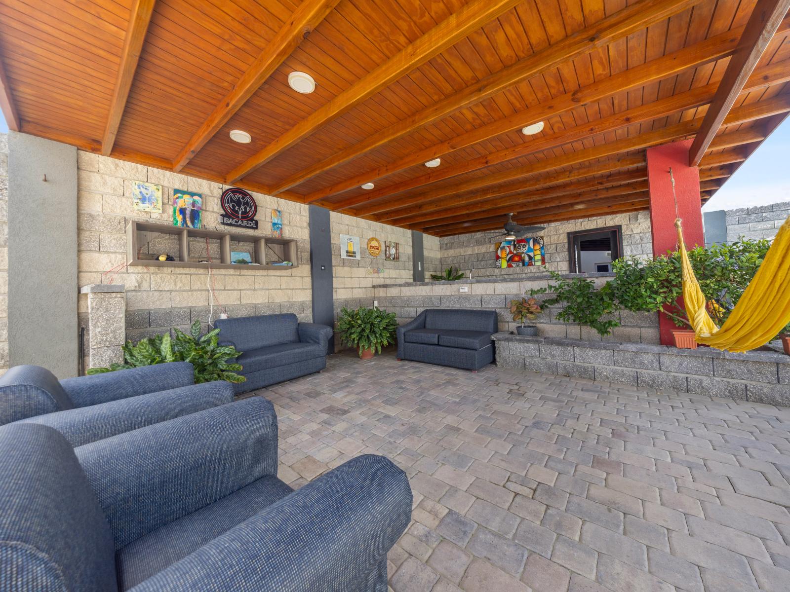 Experience the joy of outdoor living with cozy seating area of the home in Aruba - Discover outdoor relaxation in this cozy seating space, ideal for enjoying the fresh air - Relax in this tranquil outdoors, surrounded by greenery and views
