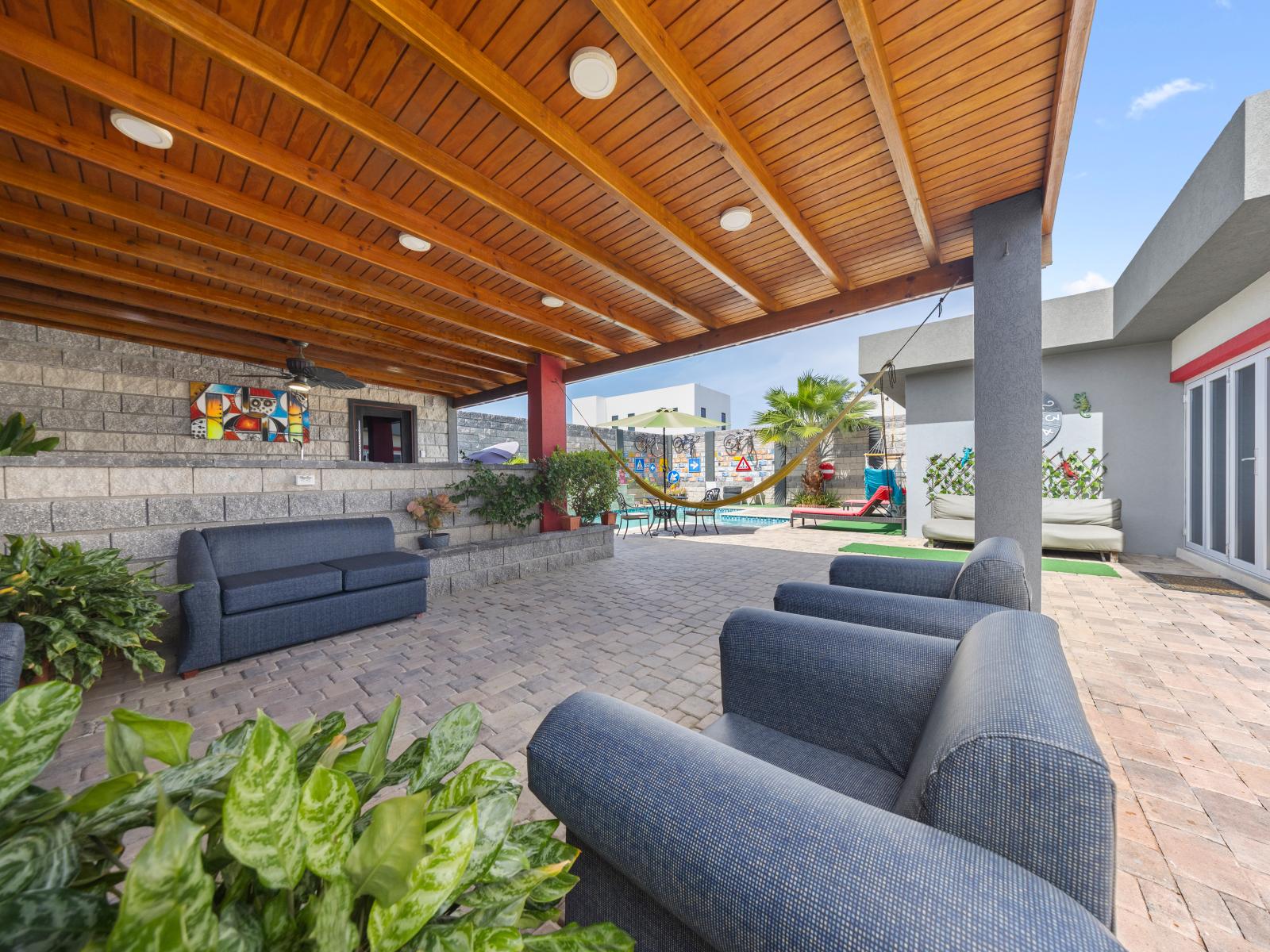 Embrace the beauty of outdoor living in this serene seating area of the home in Aruba - Savor the peaceful atmosphere of this outdoor seating spot, where relaxation takes center stage - Discover your own slice of paradise with plush seating & views