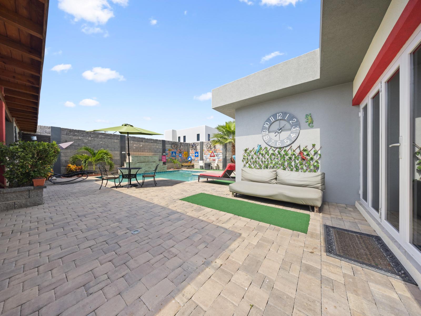 The backyard is overflowing with creative art designs of the home in Aruba - Create lasting memories with loved ones as you gather in our picturesque outdoor area with seating - Memories are made under the open sky with sunning surroundings