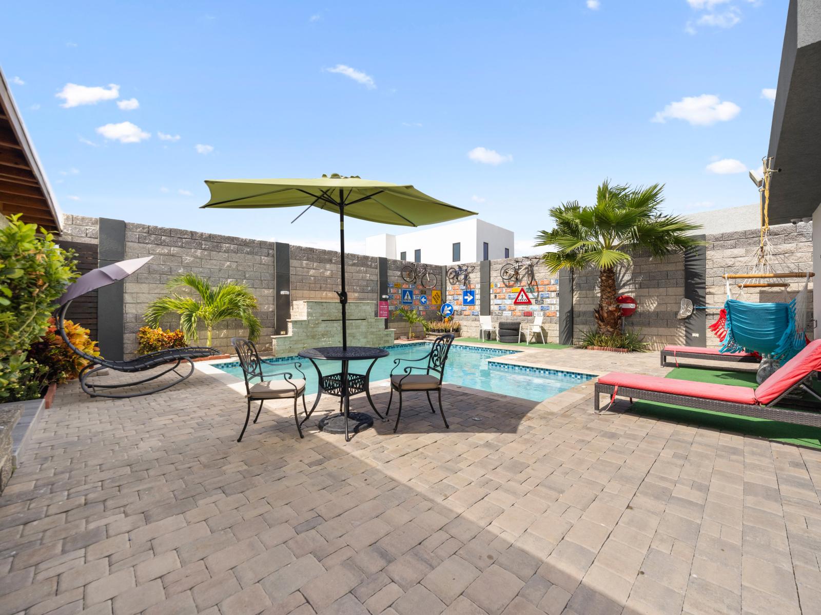 Experience outdoor living at its finest with this spacious area featuring seating, a pool, and shaded dining - Indulge in relaxation and entertainment in this outdoor oasis complete with plush seating - Dive into a refreshing poolside escape