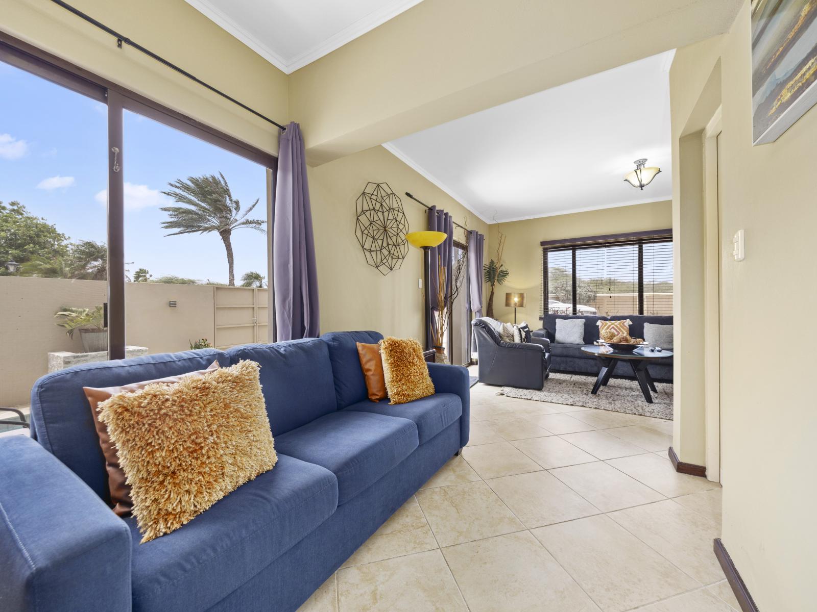 - Experience versatility in the adaptable living area of our townhouse in Noord, Aruba - Enjoy comfort in the cozy arrangement of sofas - From relaxation to entertainment the spacious living area of our townhouse caters to all.