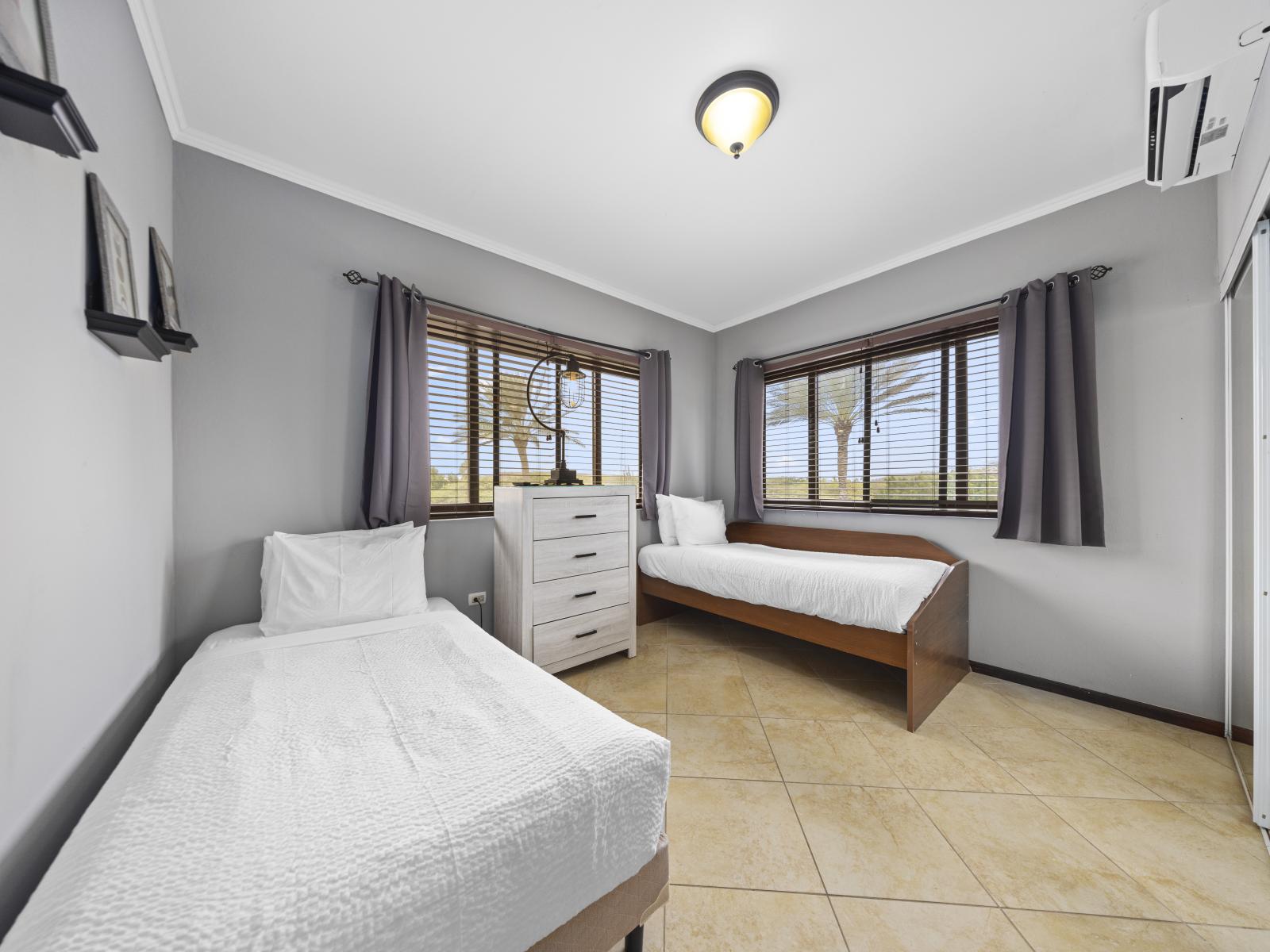 - Experience the epitome of comfort in this furnished bedroom of the townhouse in Noord Aruba - Featuring cozy twin single beds for restful night sleep - With a soothing color palette and plenty of natural light for a tranquil feel