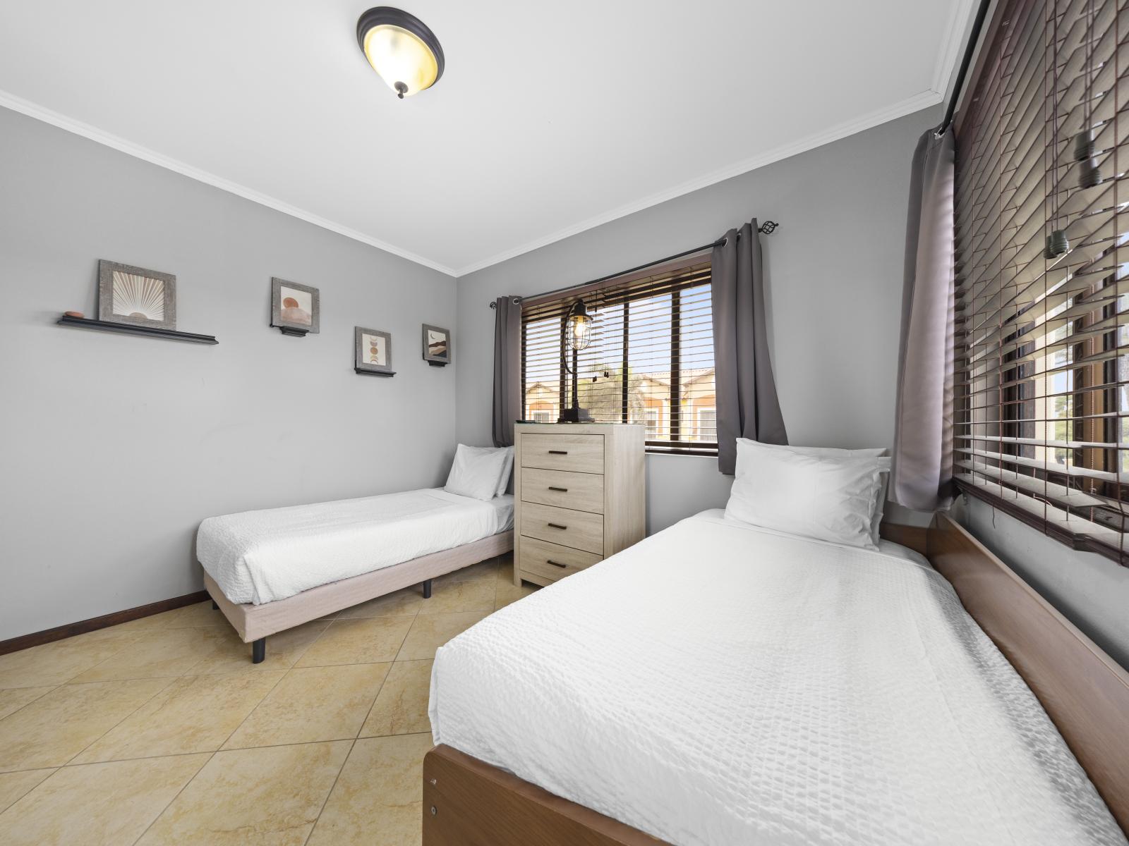 - Indulge in ultimate comfort in this fully furnished bedroom of the townhouse in Noord Aruba - Equipped with cozy twin single beds ensure a restful night's sleep - Featuring a soothing color scheme and abundant natural light for a serene atmosphere