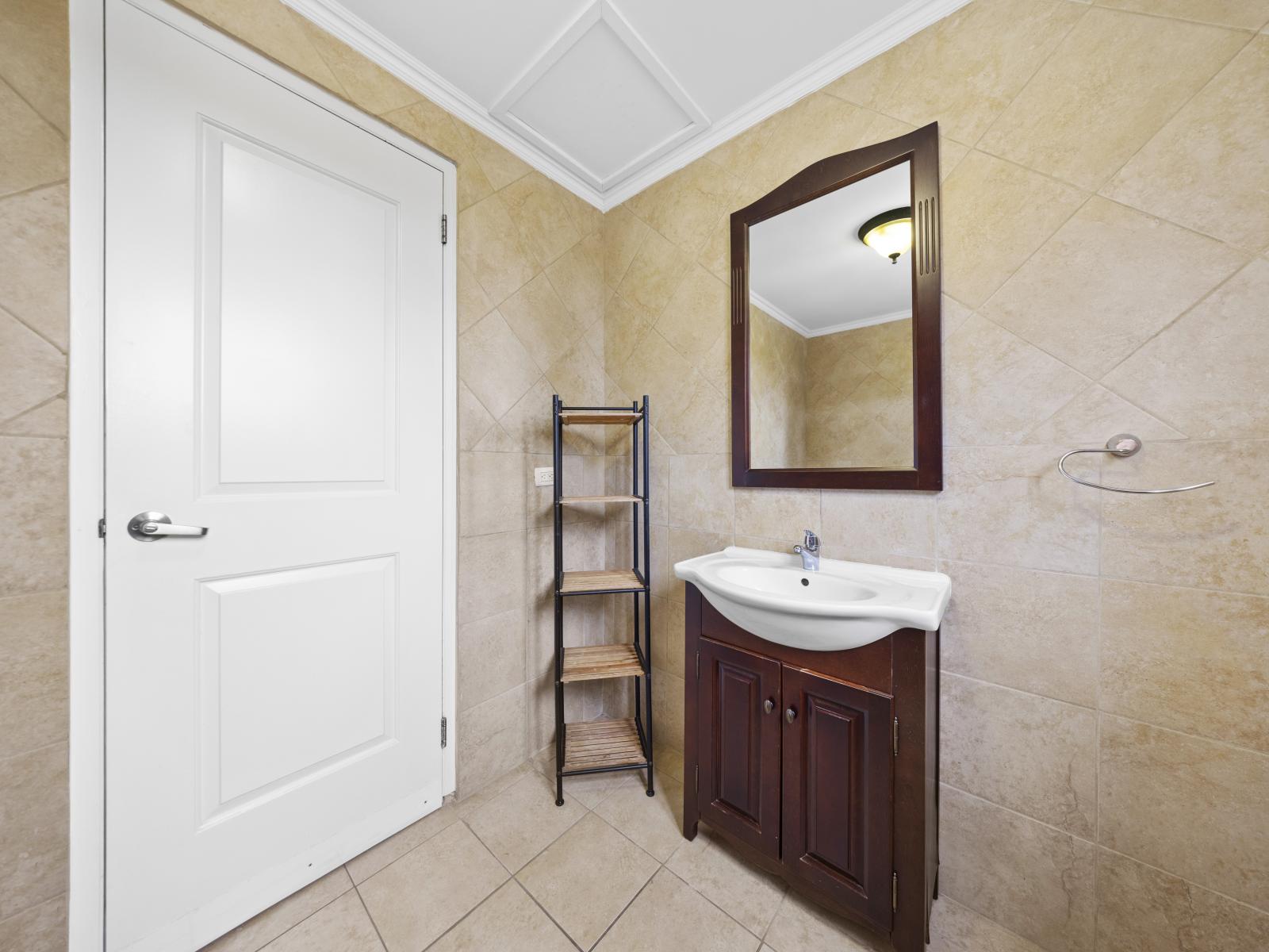 - Experience the relaxing ambiance of bathroom of the townhouse in Noord, Aruba - The bathroom is equipped with all premium amenities need - Enjoy the convenience of a well-appointed shoe rack - Beautiful wooden vanity with wooden framed wall mirror