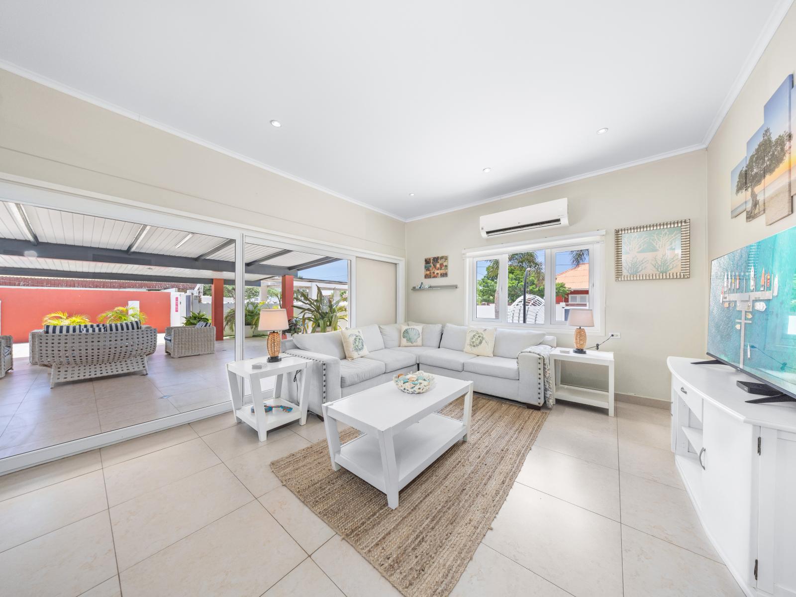 Enjoy the expansive space of the living area of the home in Oranjestad, Aruba - Sink into the plush seating, offering ultimate comfort and a cozy spot to unwind - Thoughtful accents and décor elements add character and warmth to the living space