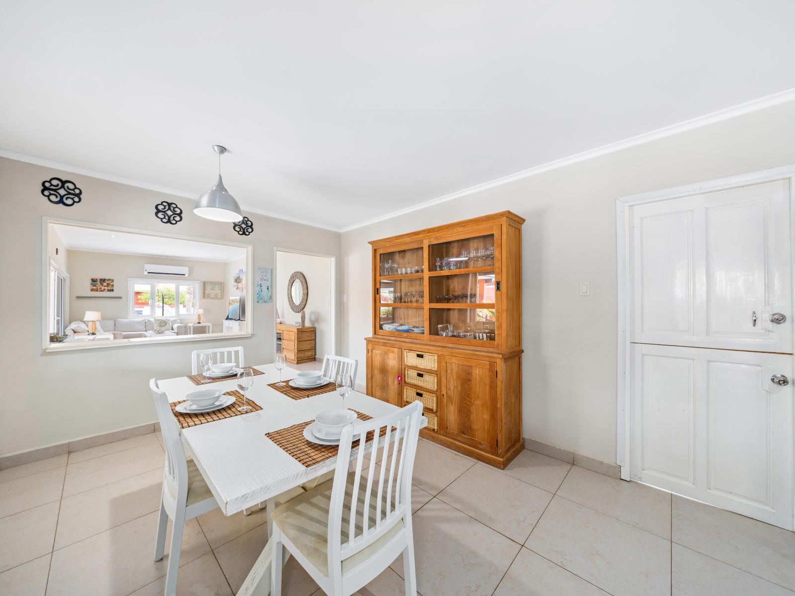 Enjoy meals in our elegant dining area of the home in Oranjestad, Aruba - The dining area is bright and airy, with large windows that let in plenty of natural light - Sophisticated décor, including tasteful art pieces and modern fixtures