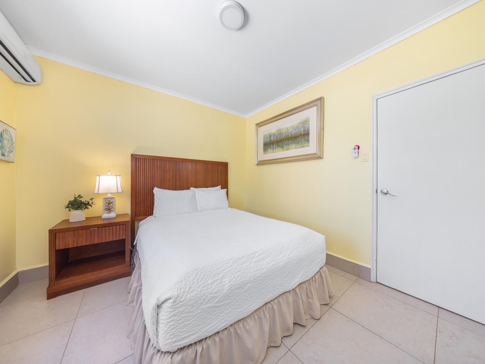 Experience a warm welcome in this inviting bedroom of the home in Oranjestad, Aruba - Sink into the comfort of a cozy double bed with fresh linens - Escape to this peaceful retreat, perfect for unwinding after a day of adventures