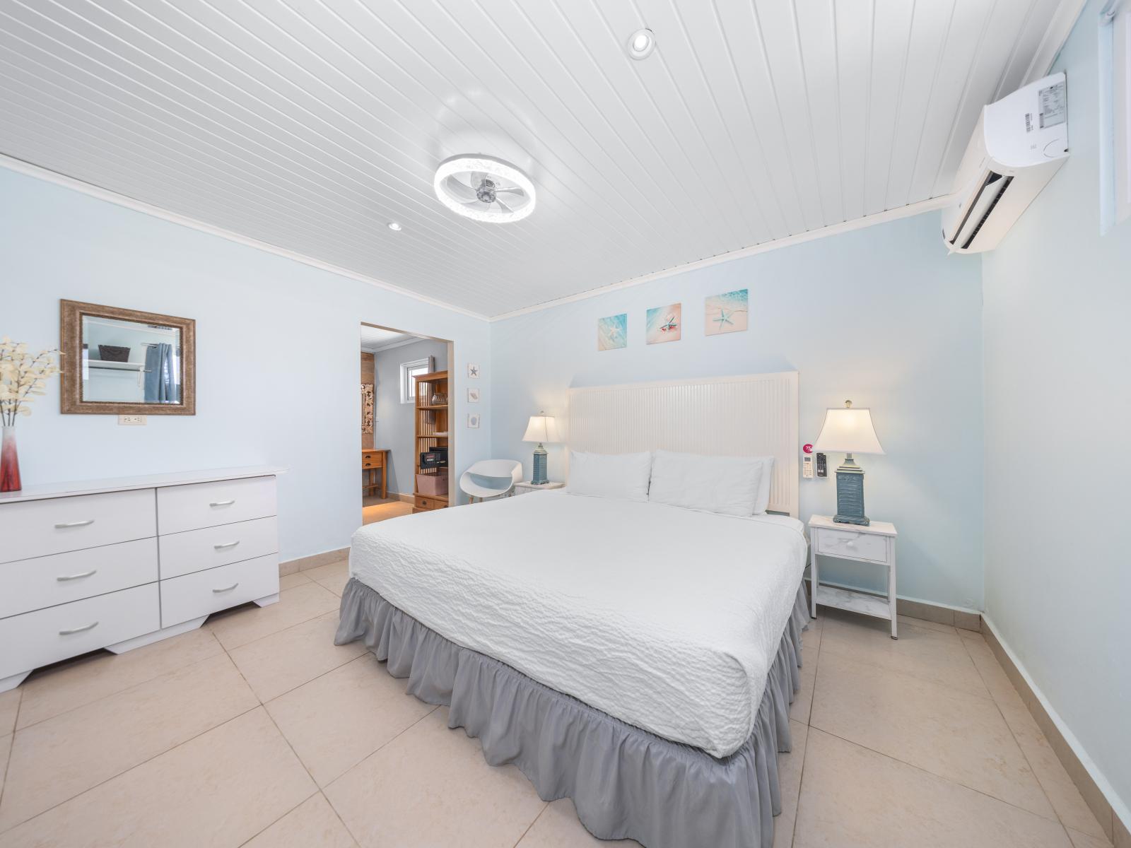 Relax in this elegantly designed bedroom of the home in Oranjestad, Aruba - Sleep soundly on a plush queen-size bed with luxurious linens and an assortment of soft pillows - Indulge in majestic decor with availability of smart TV for entertainment