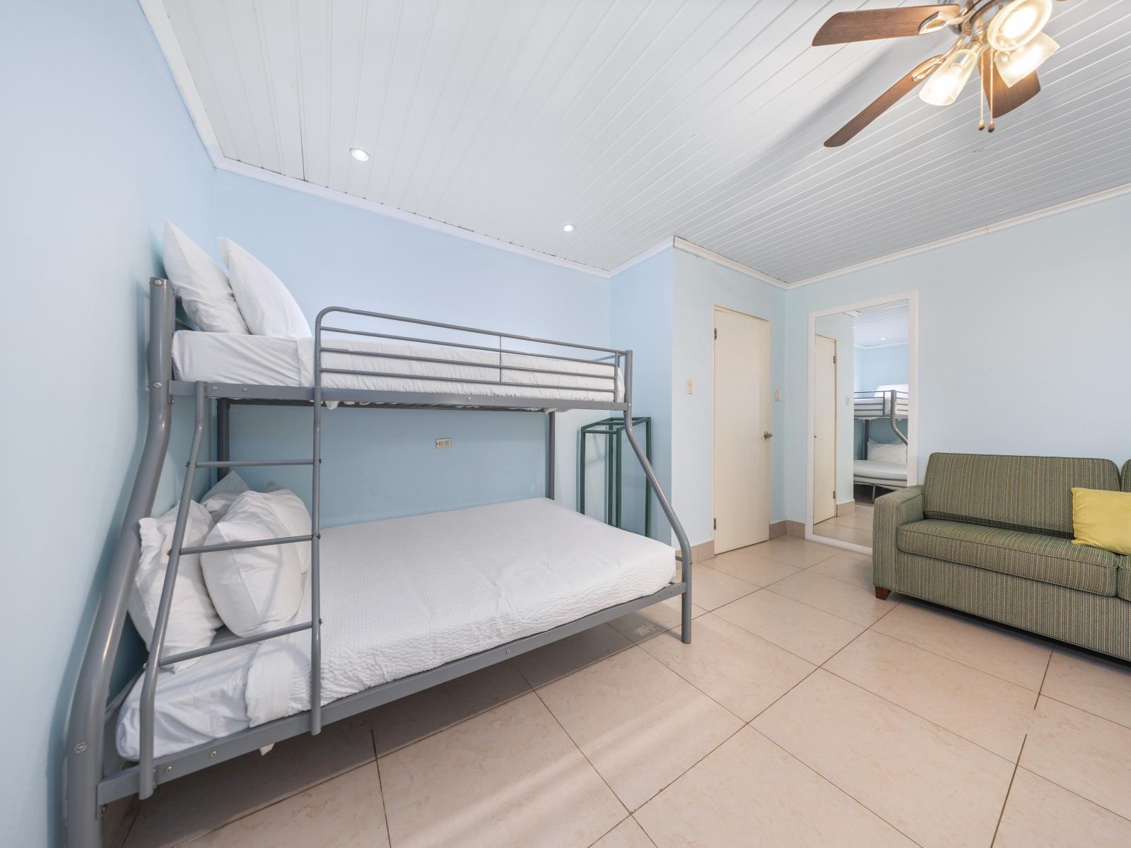 Discover serenity and style in this elegant  bedroom of the home in Oranjestad, Aruba - Enjoy a comfortable bed with soft linens and cozy sofa to relax - Bright and airy with natural light, creating a welcoming atmosphere - Enjoy availability of TV