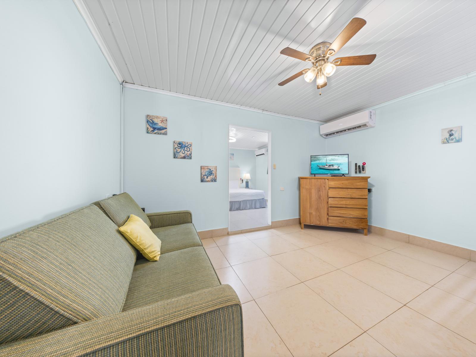 Experience sophistication in the bedroom of our Oranjestad, Aruba home - Unwind in the plush bunk bed and a cozy sofa - Bathed in natural light, the room exudes a warm and inviting ambiance - Enjoy the convenience of a television for entertainment