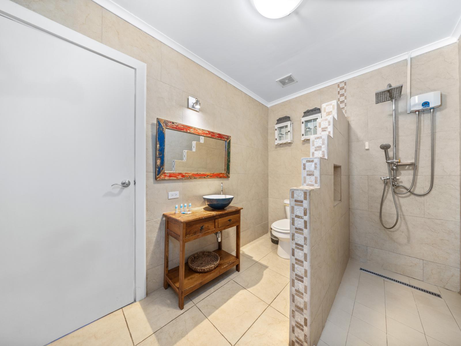 Experience modern elegance in this beautifully appointed bathroom of the home in Oranjestad, Aruba - Stay organized with plenty of storage space for your personal care items - Impeccably clean and maintained, ensuring a comfortable experience