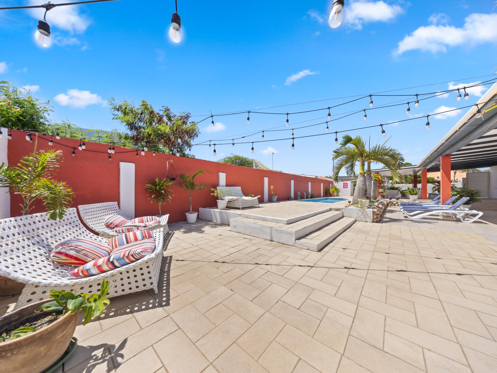 Relax in our inviting outdoor sitting area of the home in Oranjestad, Aruba - Beautifully decorated with stylish and modern outdoor furniture - Take in the stunning views of the surrounding landscape from the outdoor sitting area